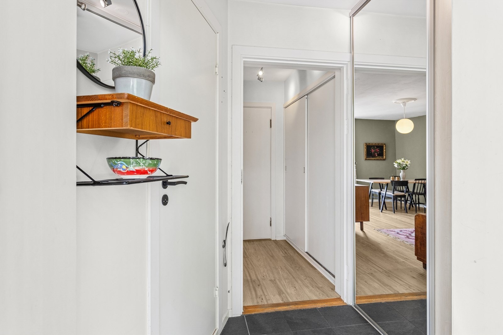 Vel innenfor døren er det en lys og romslig entré med flislagt gulv og lyse vegger. Galleribilde