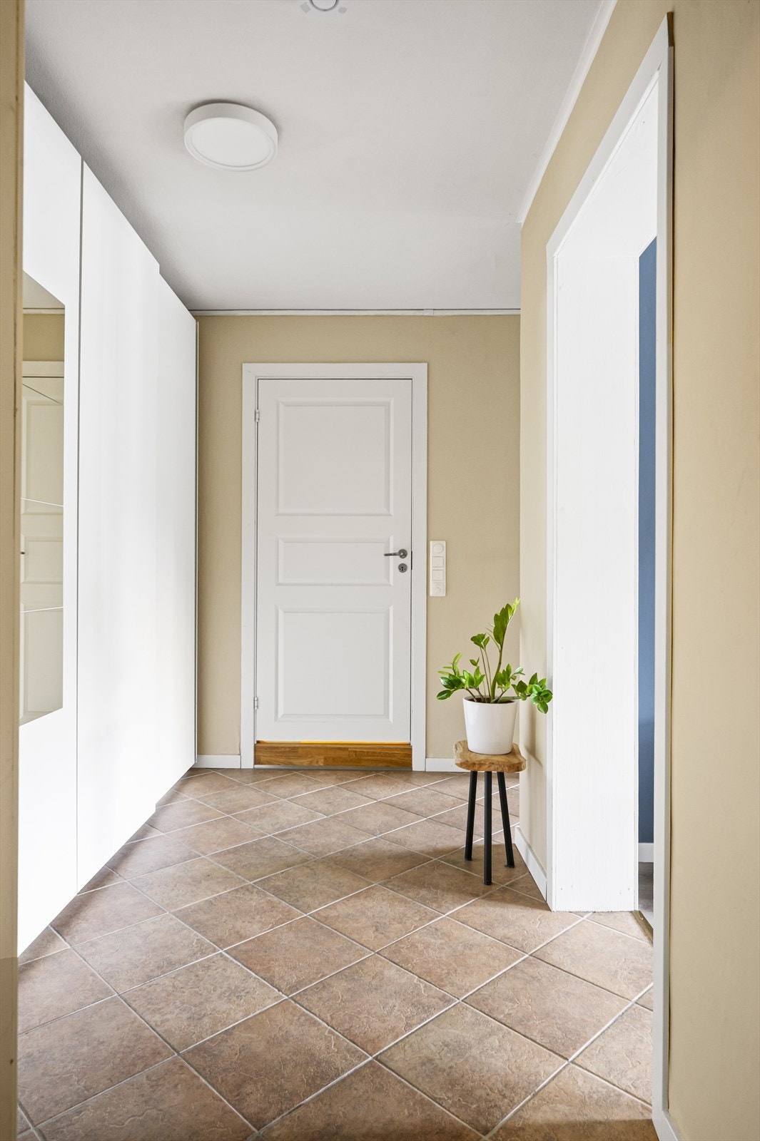 Velkommen inn! Flisene i gangen tåler en støyt, og leder deg til alle rom i leiligheten. Her er det nok av plass til å henge fra seg yttertøy og sko Galleribilde