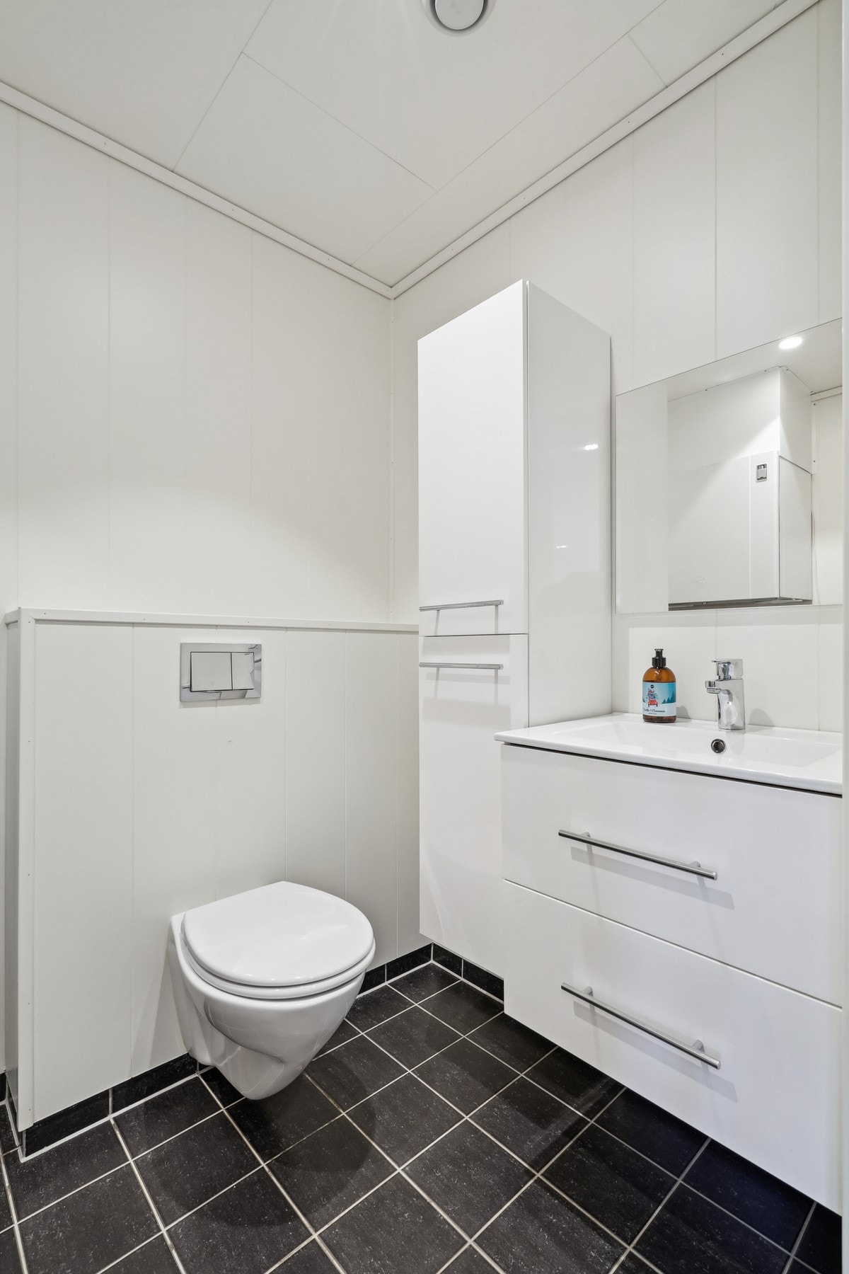 I 1.etasje er det en flislagt bod som i dag benyttes som toalettrom. Her er det utstyrt med vegghengt toalett og et romslig baderomsmøbel med nedfelt servant. Galleribilde