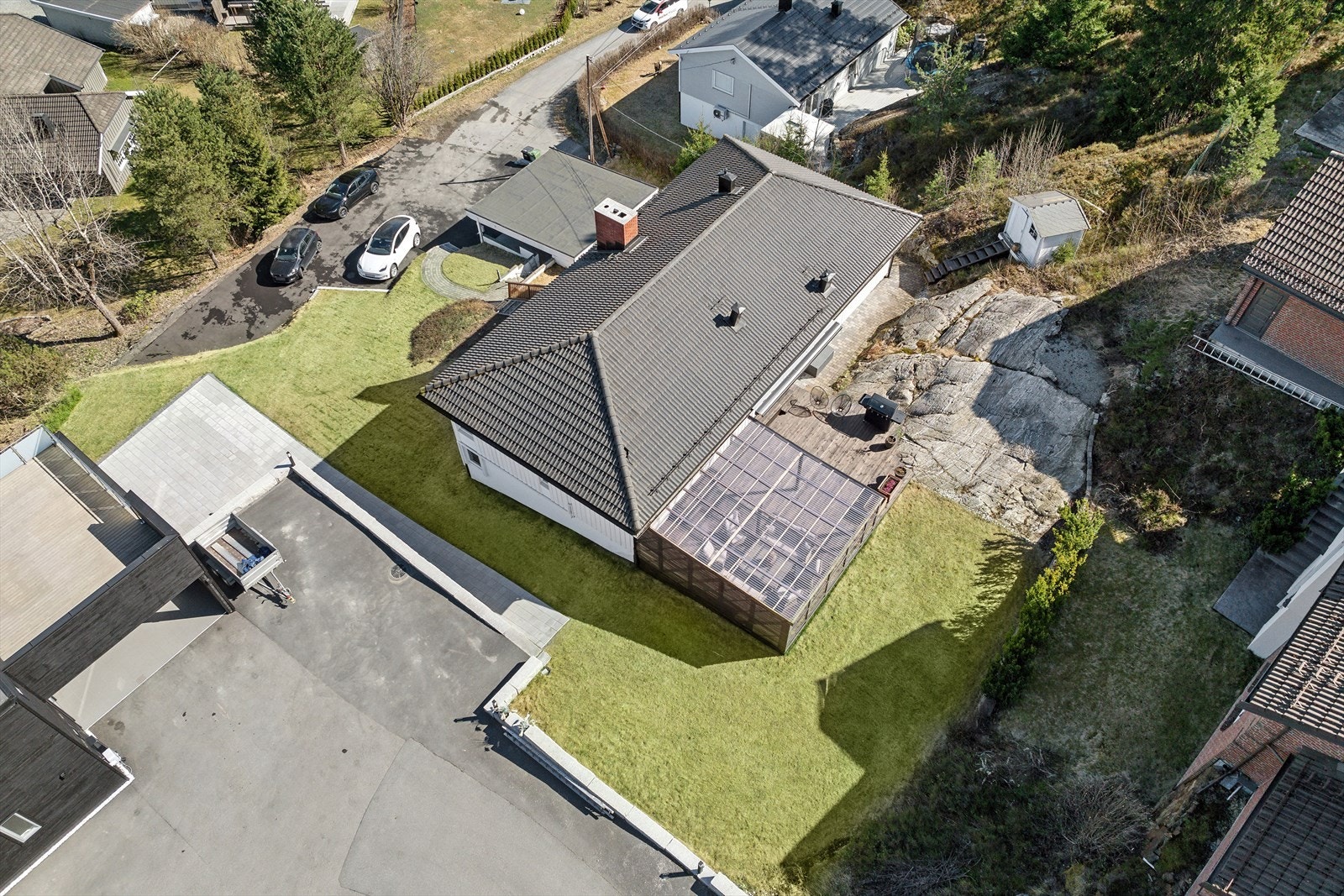 Tomten er opparbeidedet med plener, bed, busker, utvendig platting på oversiden og måler 1 300,2 kvm. Galleribilde