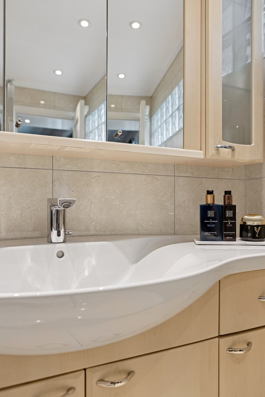 Videre er det servant med ettgrepskran, skuffer og skap under, samt overskap med speil. Galleribilde