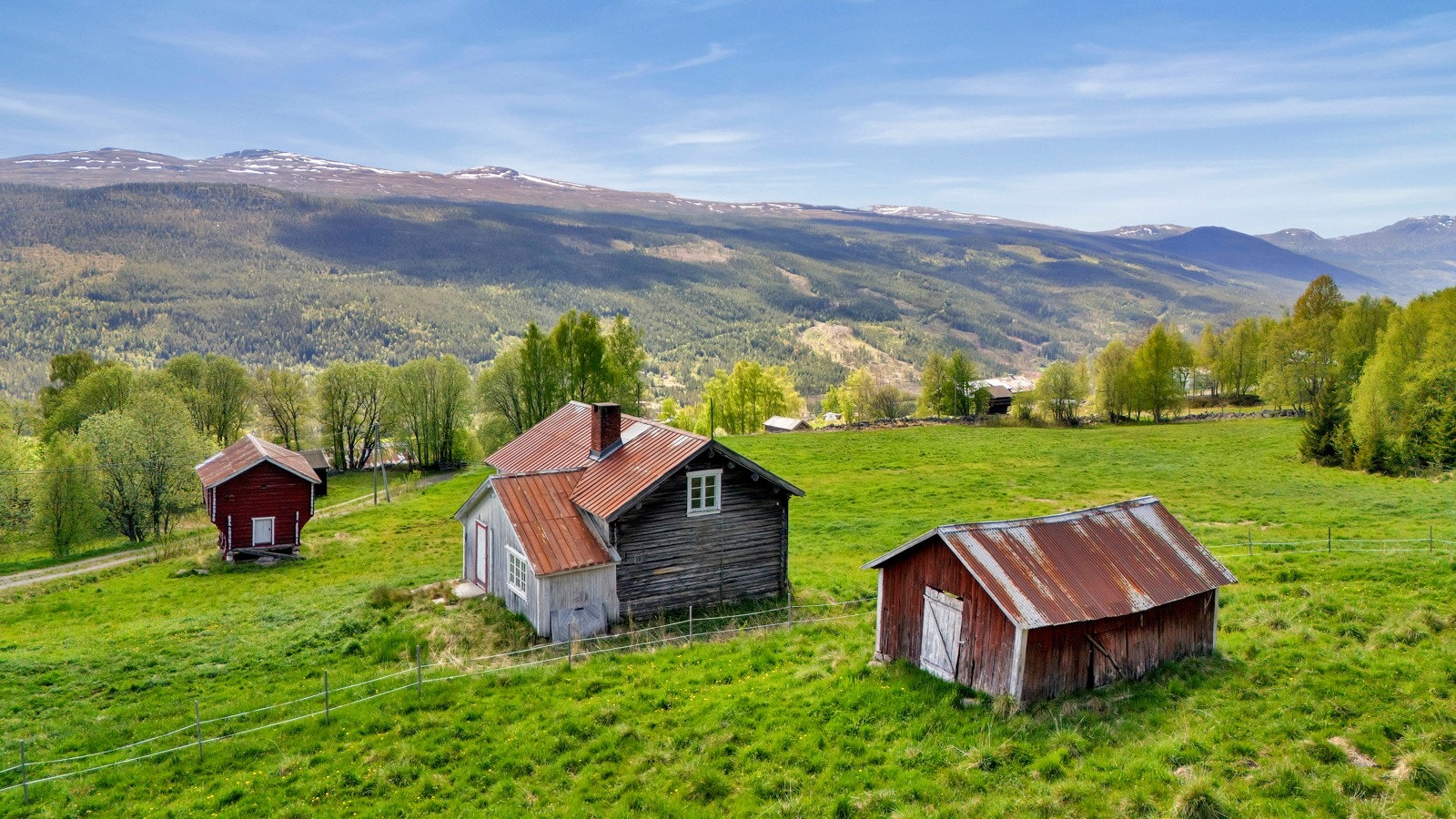 Oversiktsbilde av tunet ? idyllisk beliggende med åpen utsikt over dal og fjell. Galleribilde