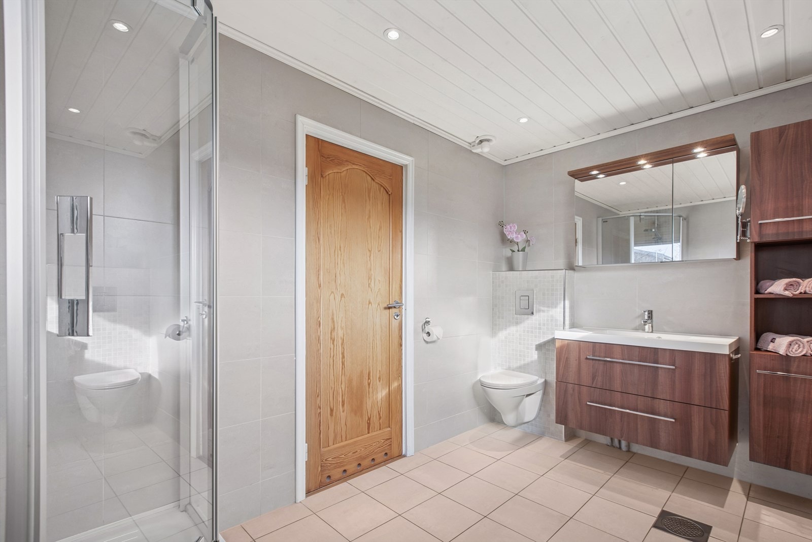 Delikat, flislagt bad fra 2009. Badet er innredet med dusjnisje med innfellbare glassdører, toalett og servantinnredning. Galleribilde