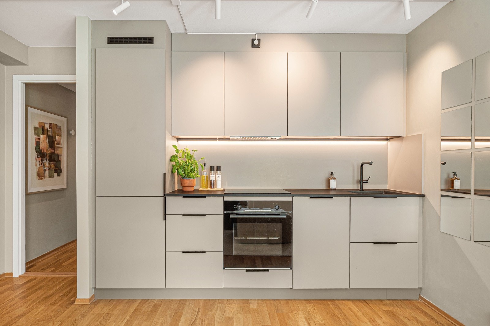 KVIK kjøkkeninnredning fra 2022 med glatte fronter i leilighetens gjennomgående lyse farge Galleribilde