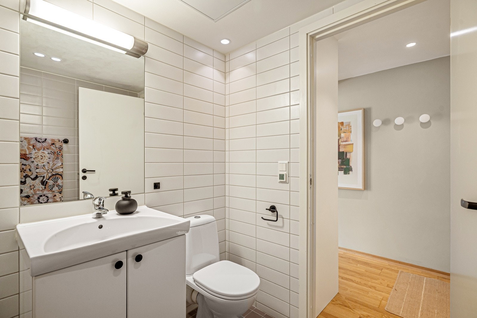 Rommet har integrert speil med overlys og hvit servant Galleribilde