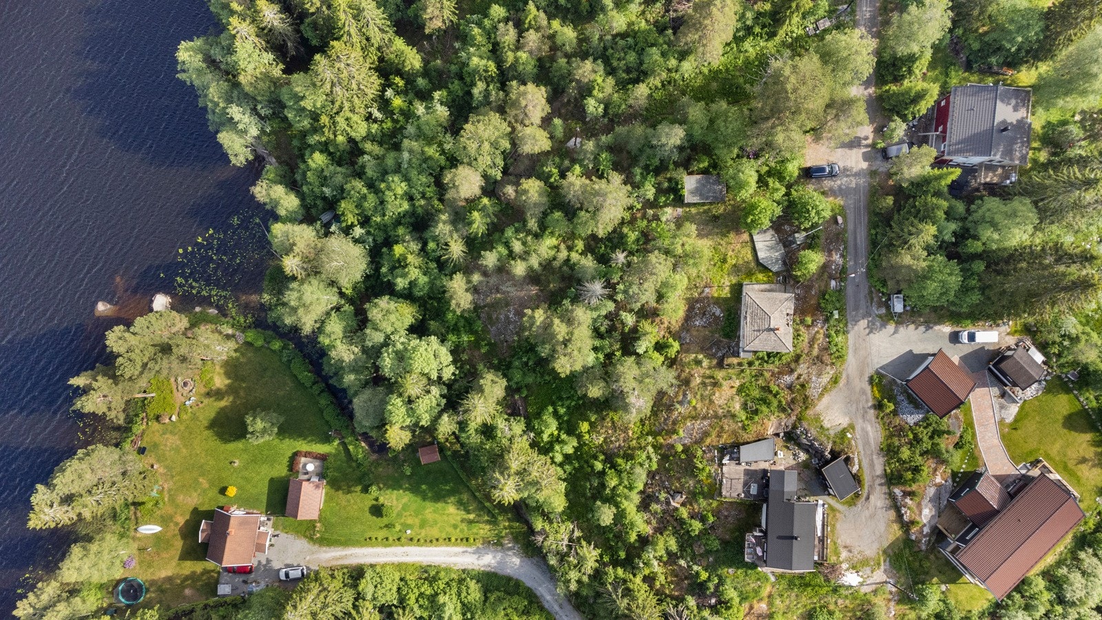 Tomten består av vakker naturtomt med gress, flotte, frodige trær, annen naturlig vegetasjon og fjell i dagen. Galleribilde