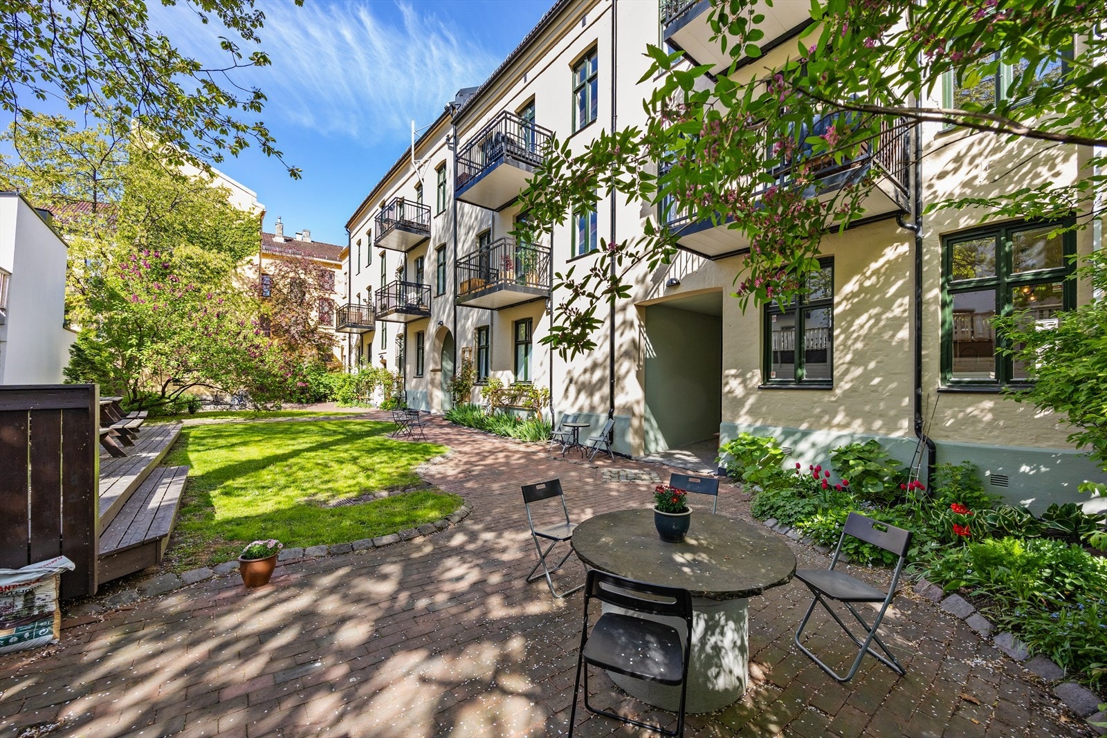 Velholdt bakgård med blomsterbed og sitteplasser. Galleribilde