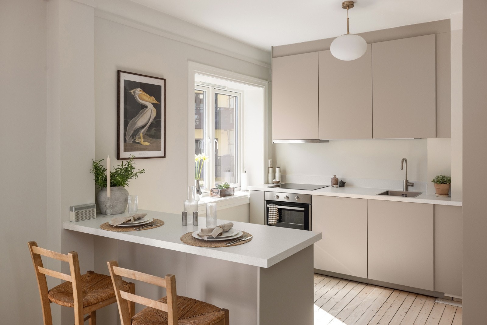 En fin halvøy deler naturlig av mot stuen, gir ekstra god skap- og benkeplass, samt en hyggelig sitteplass med barstoler. Galleribilde