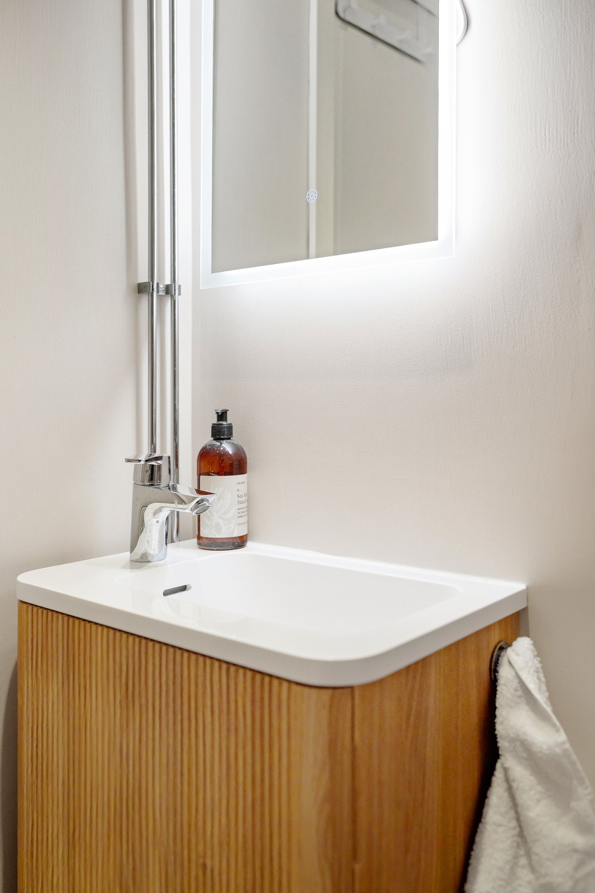 Lekker ny baderomsinnredning med heldekkende servant tilkoblet ett-greps blandebatteri og skap for oppbevaring. Vegghengt speil med belysning over servant. Galleribilde