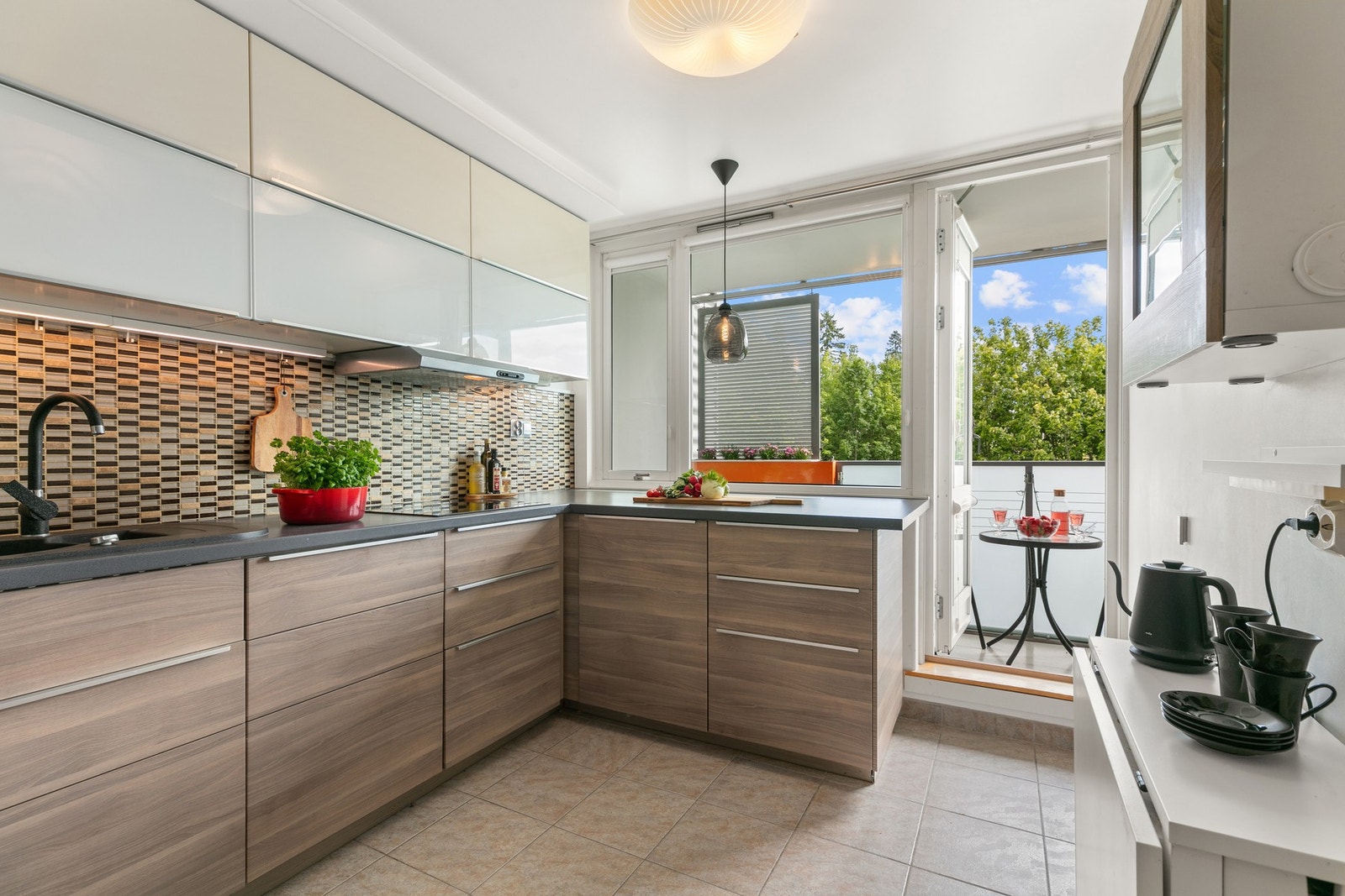 Kjøkkenet er lyst og tiltalende med utgang til en sørvendt overbygget balkong Galleribilde