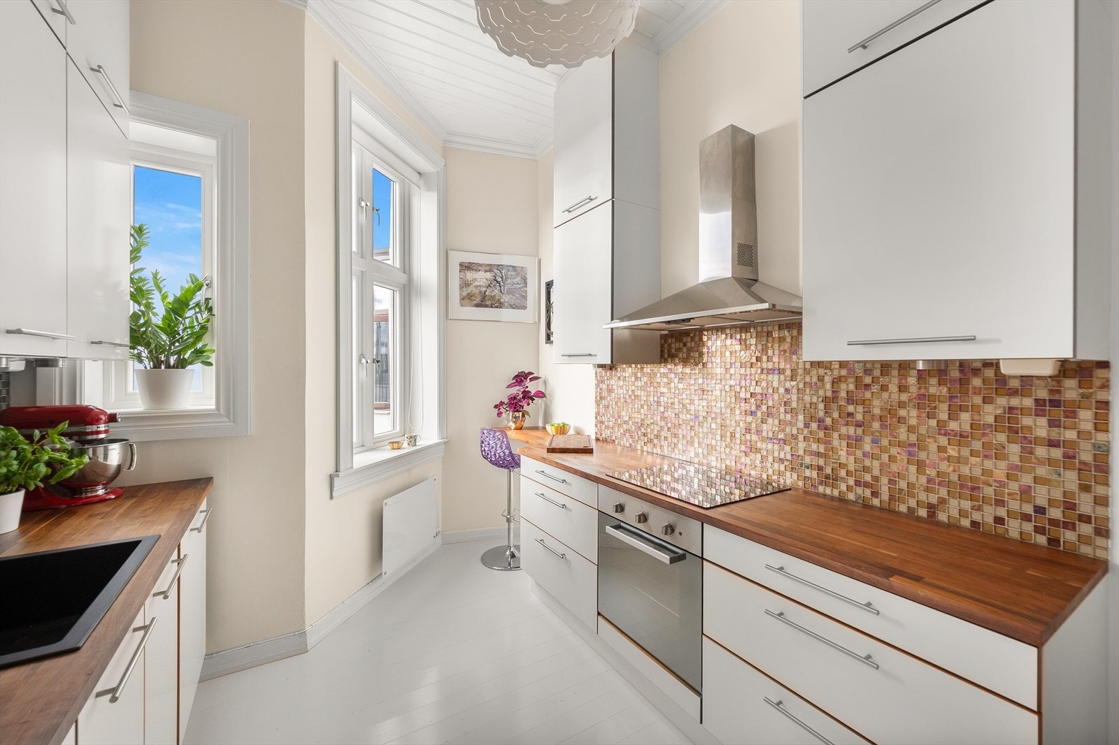 Kjøkkeninnredningen består av lyse, slette fronter og benkeplate i heltre med nedfelt vask (2020). Galleribilde