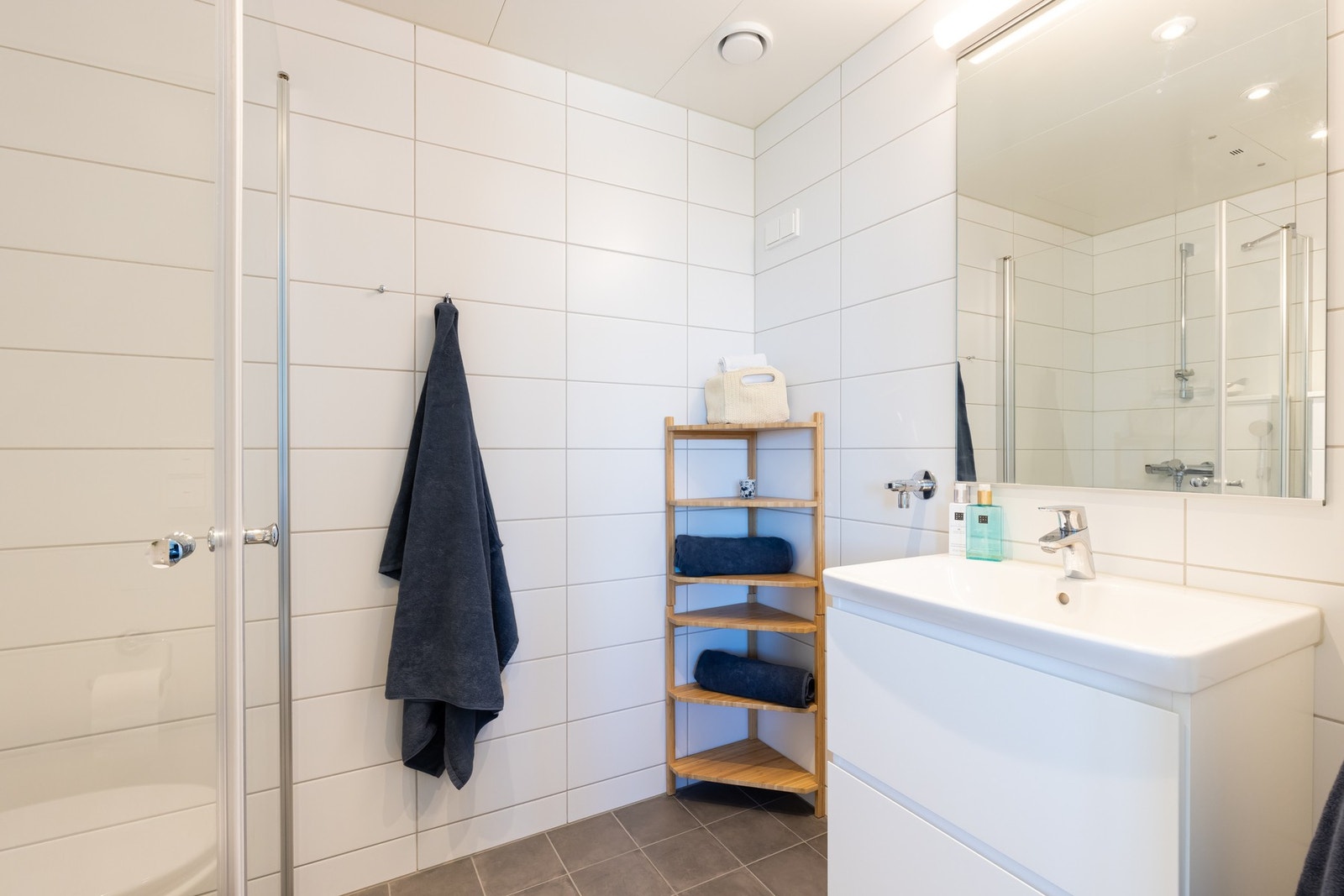 Rommet er innredet med baderomsinnredning med nedfelt servant og speil med belysning. Galleribilde