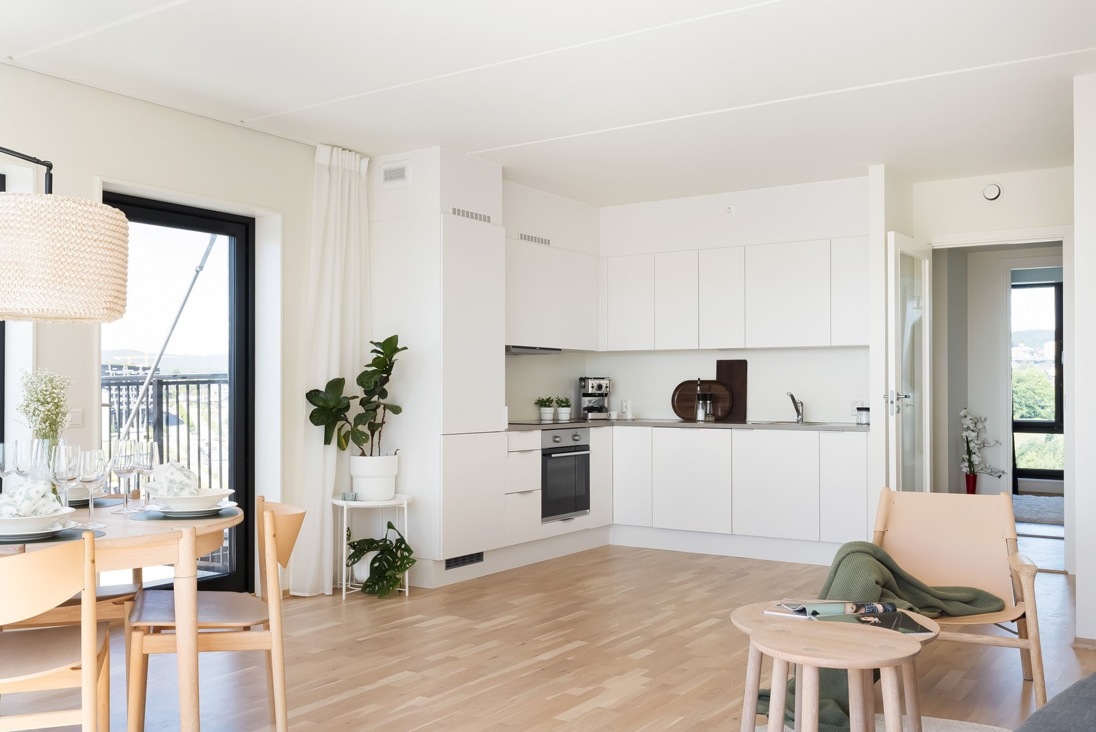 Lyst og delikat Norema-kjøkken består av lyse, fabrikklakkerte, fronter med benkeplate i laminat og nedfelt oppvaskkum med ett-greps armatur. Galleribilde