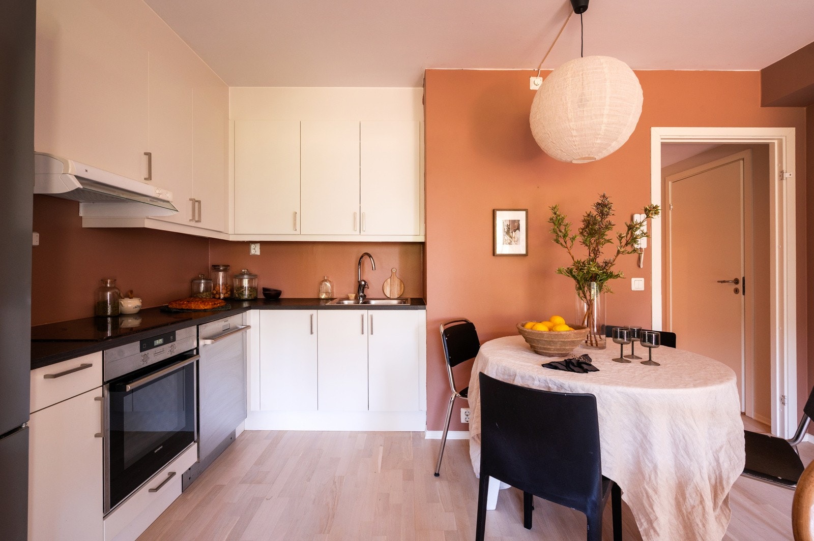 Kjøkkenet er innredet med hvite glatte skapfronter, laminat benkeplater Galleribilde