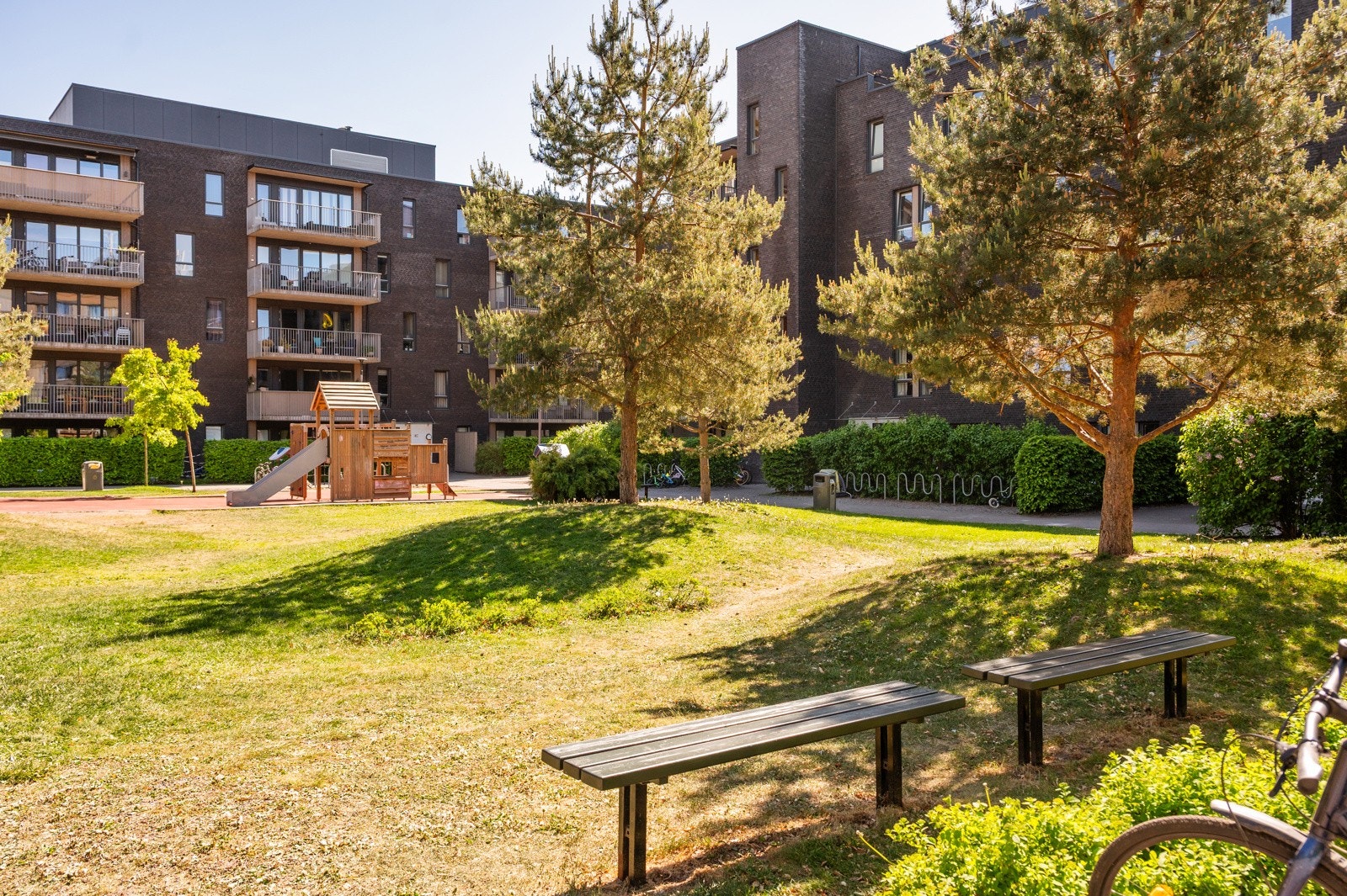 Parkanlegg i umiddelbar nærhet til blokken med lekeapparater, bekk, vannspeil, gangbru, beplantning og bålplass. Galleribilde