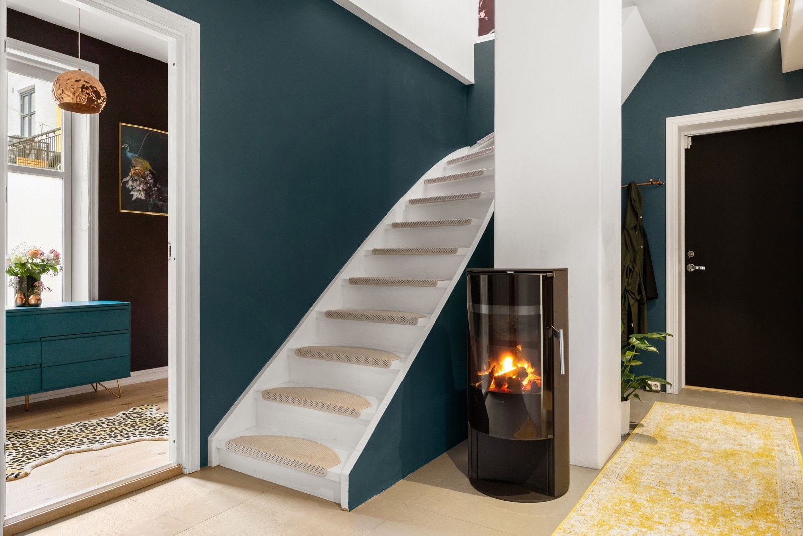 Trappen tar deg enkelt ned til boligens underetasje. Gangen byr blant annet på en hyggelig peisovn som gir varme, og det er integrert belysning i himlingen. Galleribilde