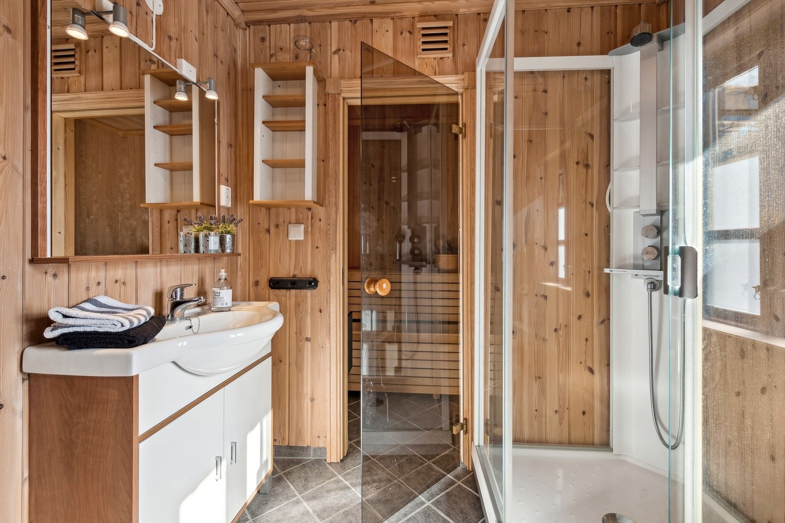 Nesten som på spa. Badet er utstyrt med dusjkabinett og badstue, noe som gir en luksuriøs og avslappende spa-opplevelse rett hjemme. Galleribilde