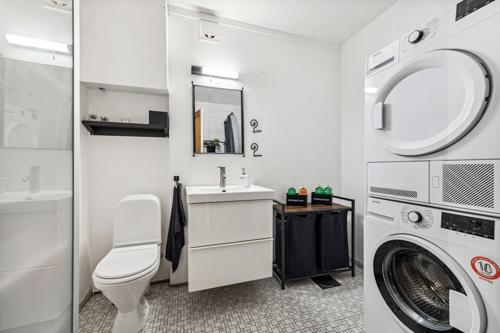 Stort bad/vaskerom med servant m/underskap, vegghengt skap, dusjhjørne med glassvegg og toalett. Galleribilde