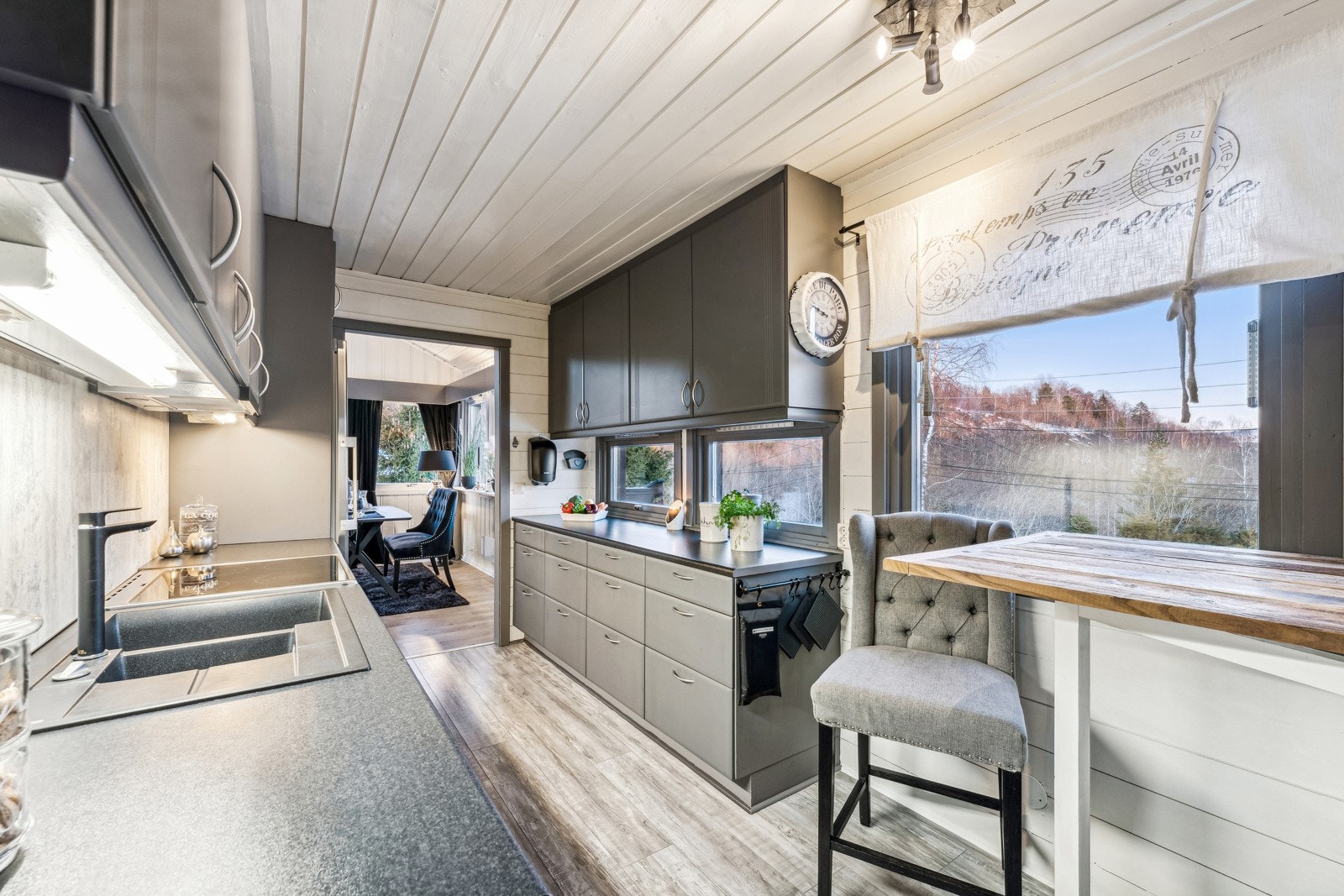 Flott kjøkken med mye skap- og benkplass. Kjøkkeninnredning med profilerte fronter. Plater mellom laminert benkeplate og overskap. Ventilator i overskap med kullfilter. Opplegg for oppvaskmaskin. Galleribilde