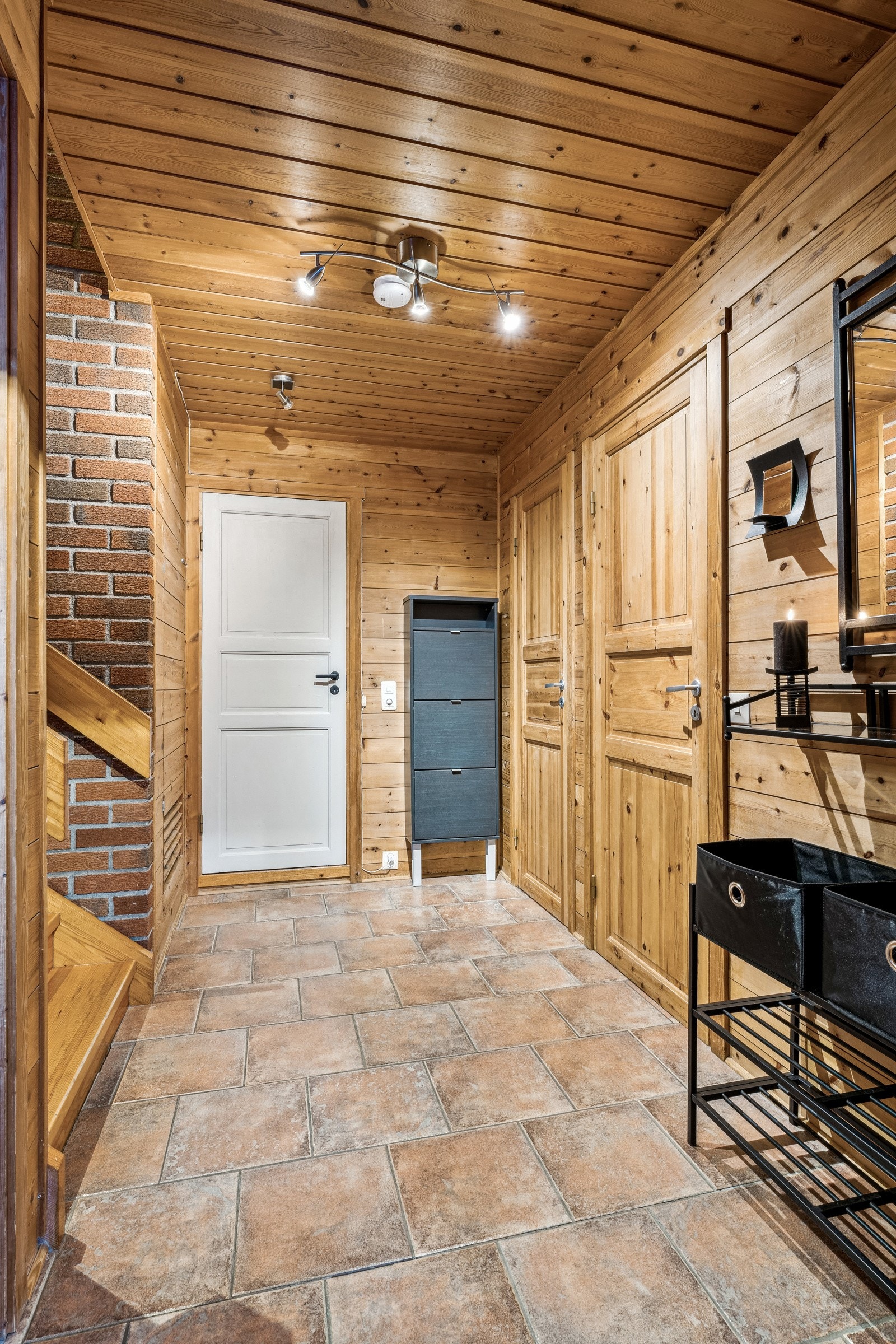 Lys og romslig entré med fliser på gulv. Her er det ikke noe problem at barna kommer inn med vått tøy etter lek i regnet. Fra entréen er det tilgang til 3 praktiske boder med mye lagringsplass. Galleribilde