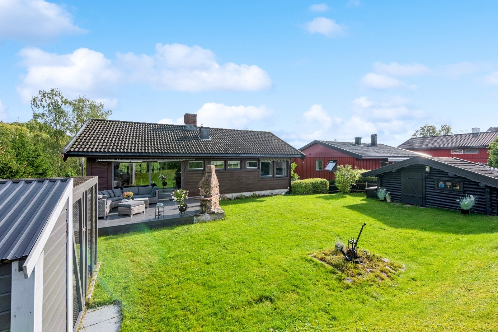 Flott gressplen som går rundt husets søndre side frem mot gårdsplassen. Galleribilde