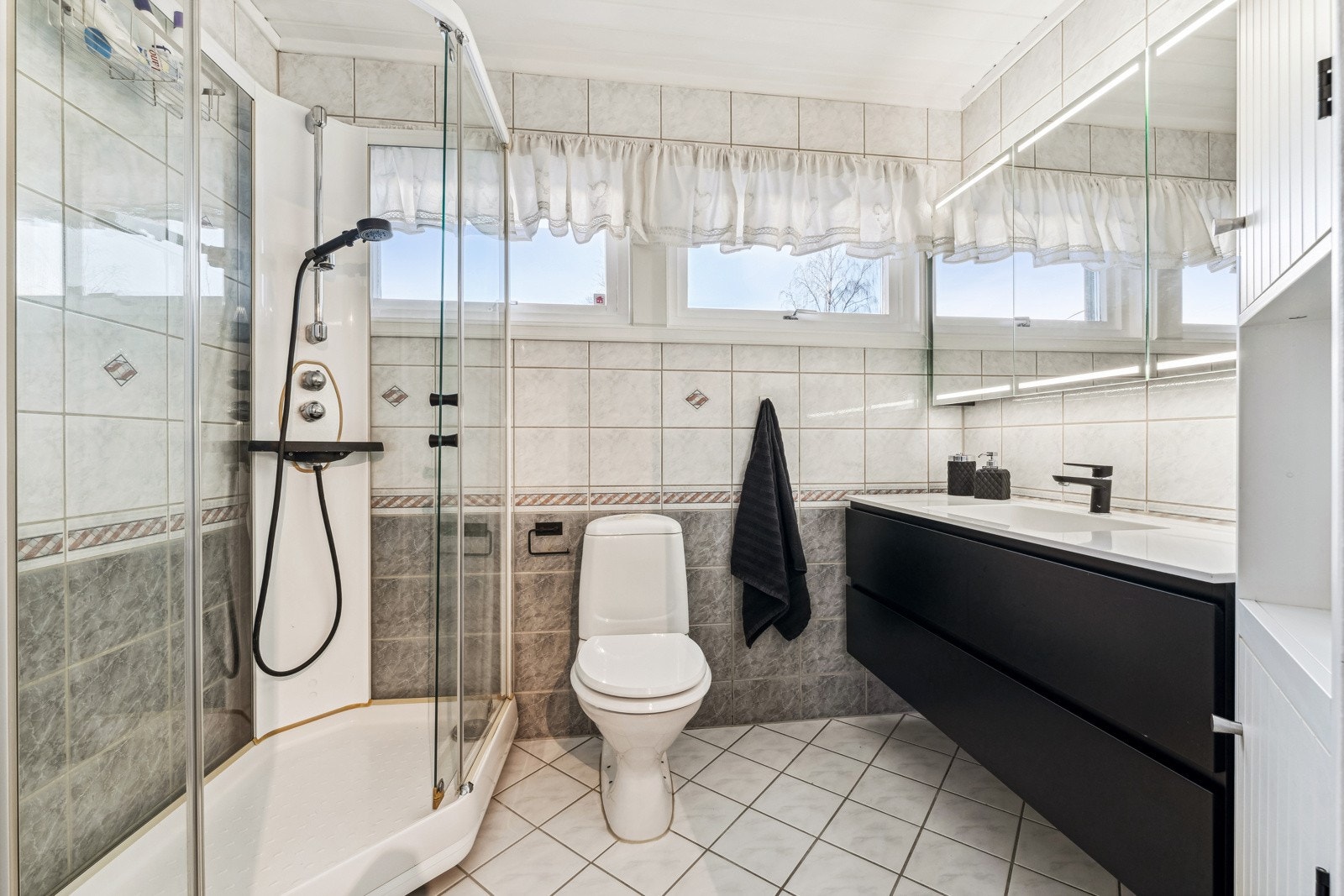 Flislagt bad som ble pusset opp i 2005. Badet inneholder dusjkabinett, servant m/over og underskap, wc og veggskap. Galleribilde