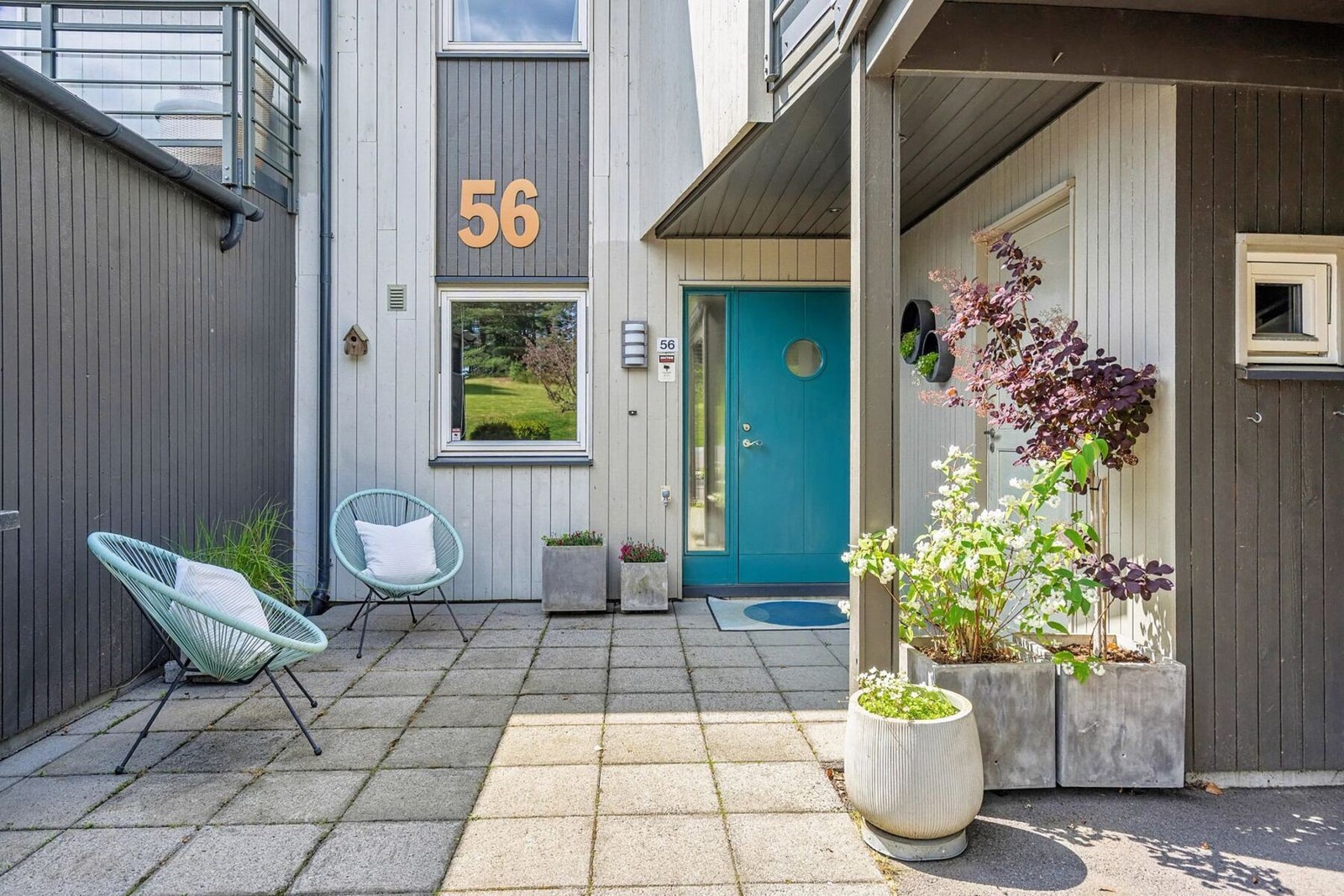 Boligen har et pent hellelagt inngangsparti, carport med elbillader og 2 uteboder. Galleribilde