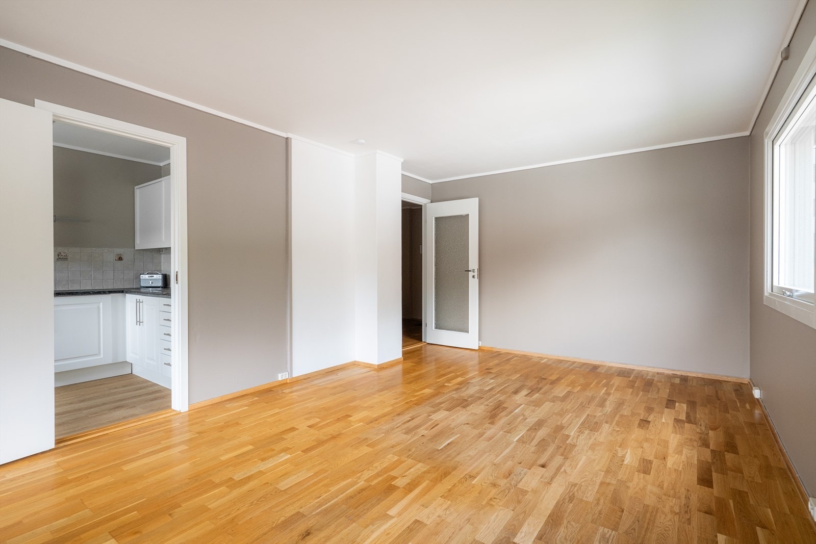 Leiligheten har en koselig stue med parkett på gulvet og et lunt og moderne fargevalg på veggoverflatene. Galleribilde