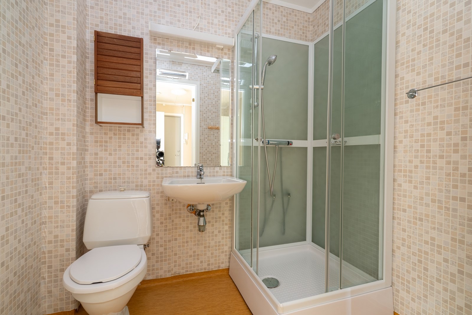 På badet er det overflater med belegg på gulv og våtromstapet på veggene. Badet er innredet med servant, speil med overlys, dusjkabinett og toalett. Badet varmes opp av stråleovn på vegg. Badet er av ukjent alder, og kan være fra byggeår. Galleribilde