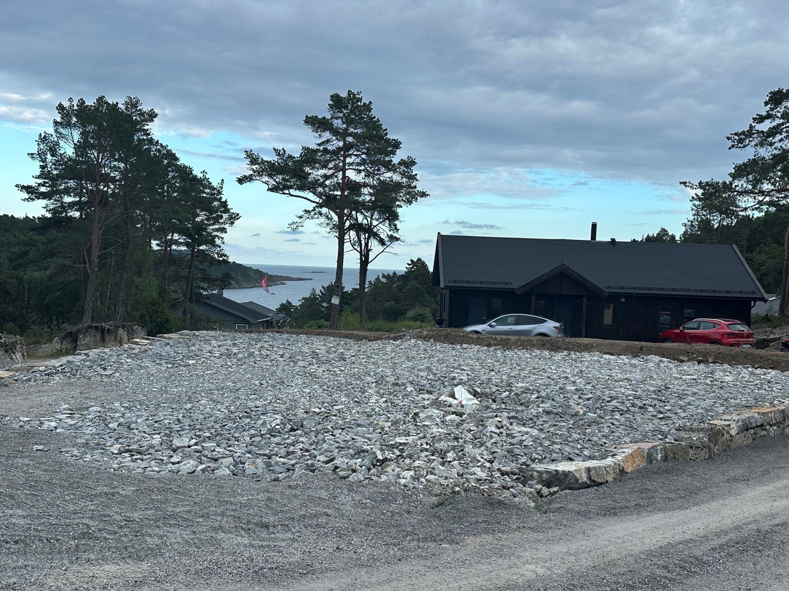 Tomten er grovplanert, komprimert og kantsatt med stein mot veien. Galleribilde