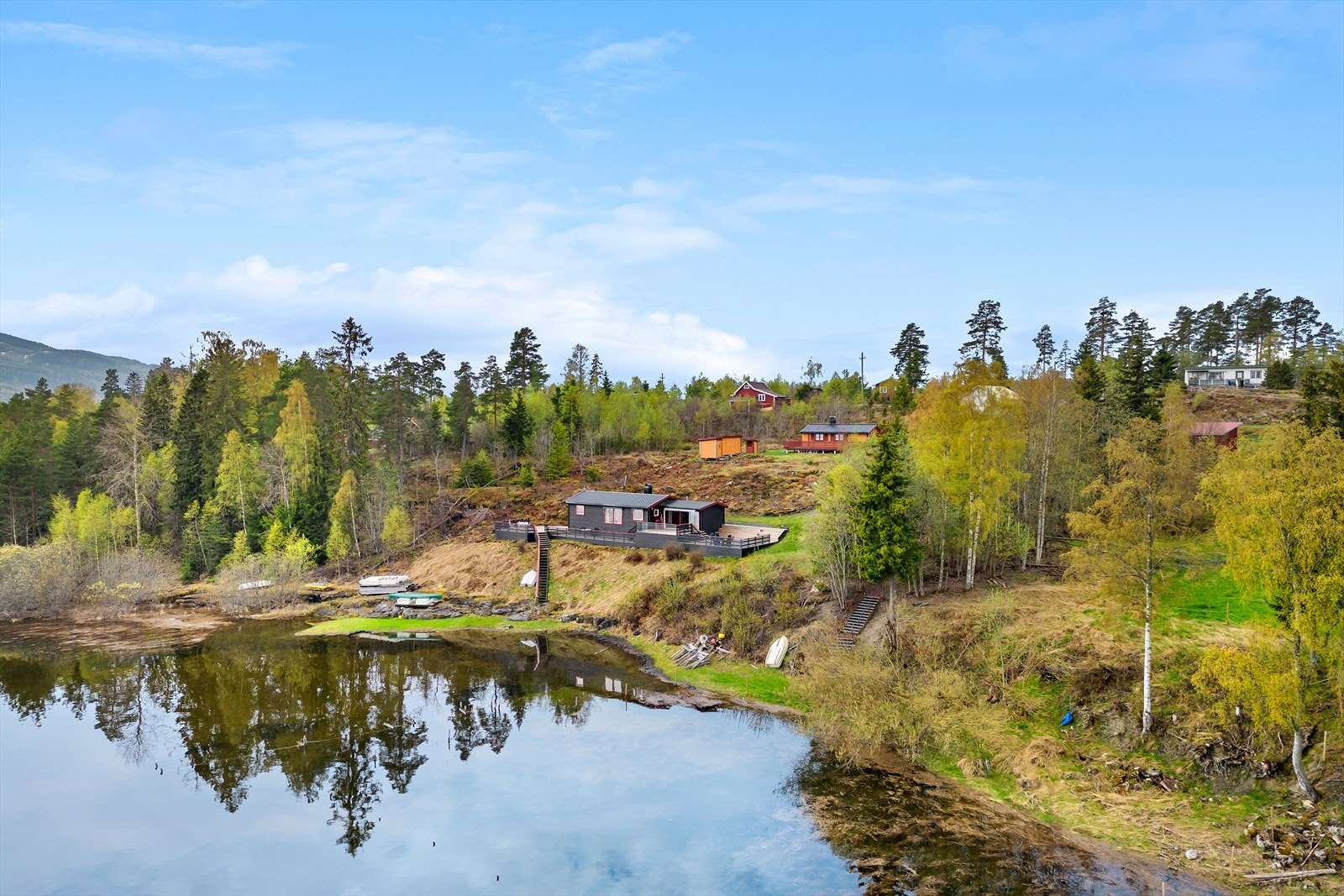 Sommerparadis ned mot vannkanten, med båt- og bryggerett. Galleribilde
