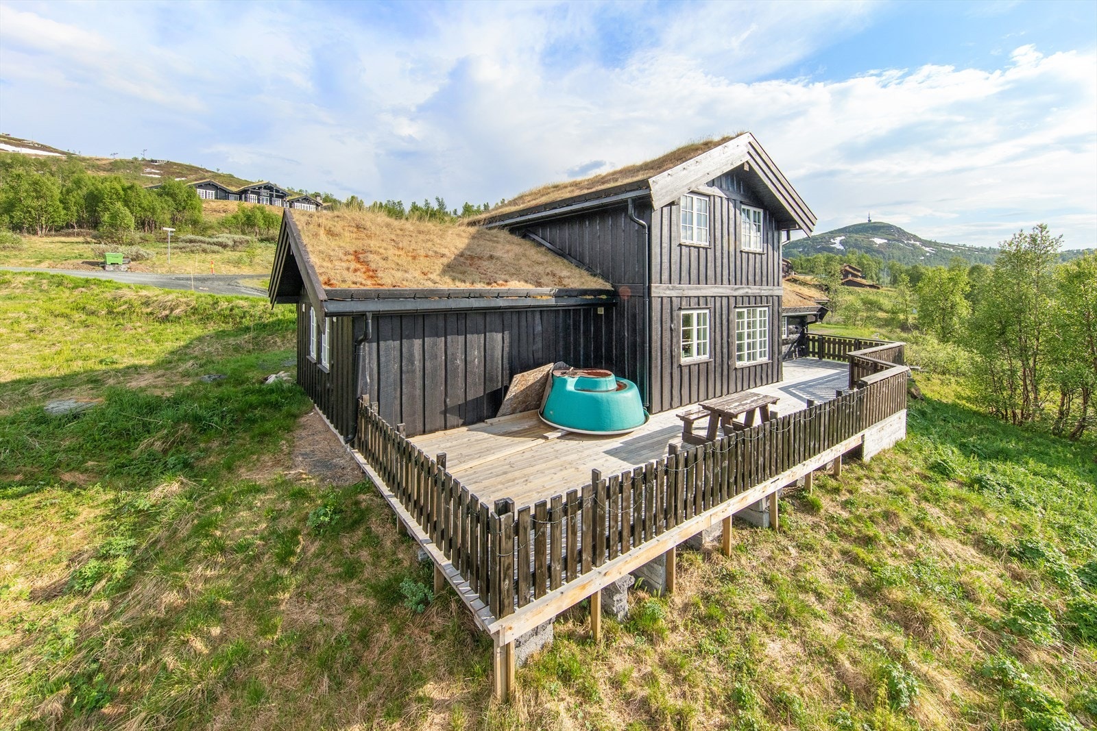 Hytta ligger fint i terrenget med stor terrasse. Galleribilde