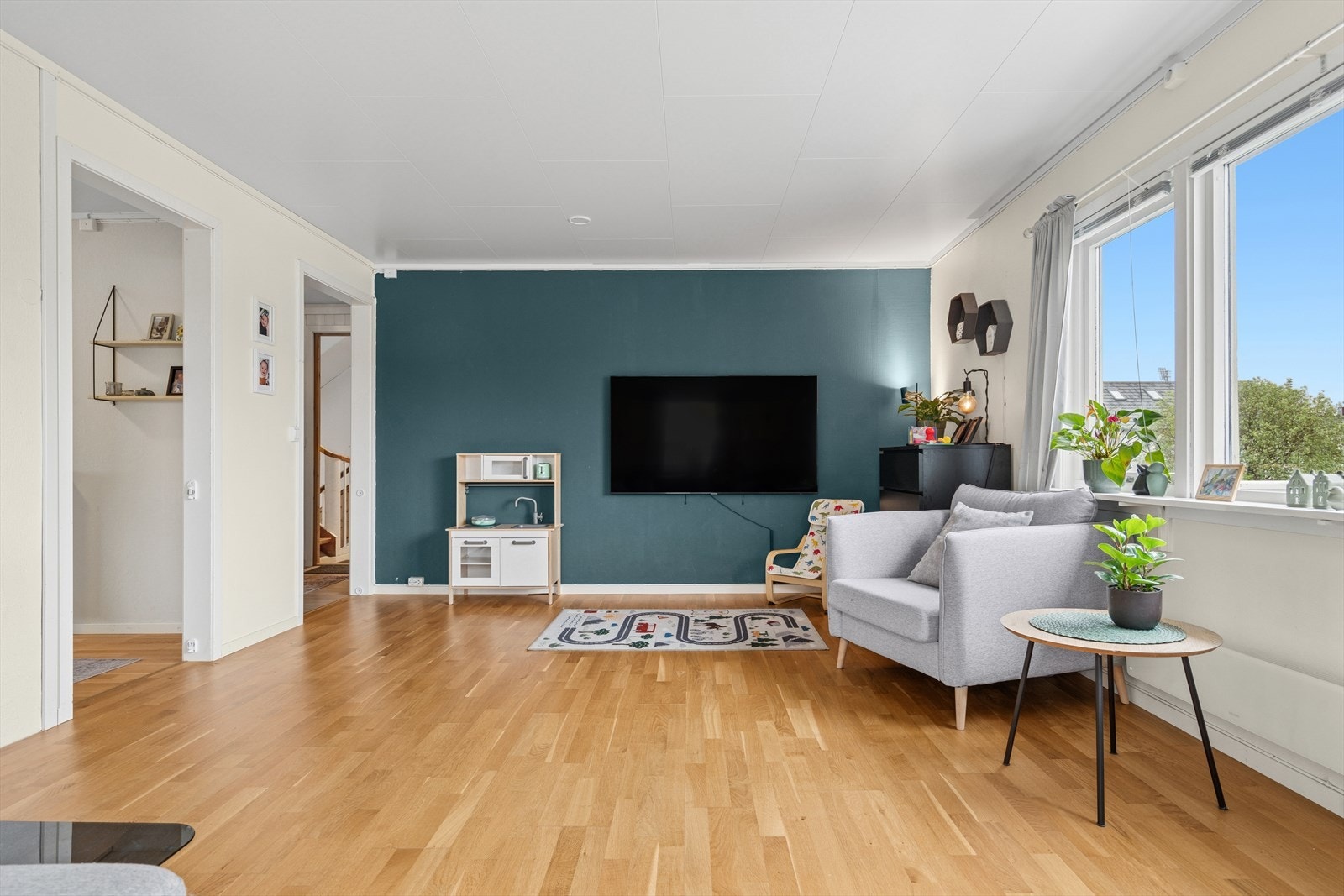 Store vindusflater på flere sider sørger for mye naturlig lys og er med på å gi stuen en luftig atmosfære. Galleribilde