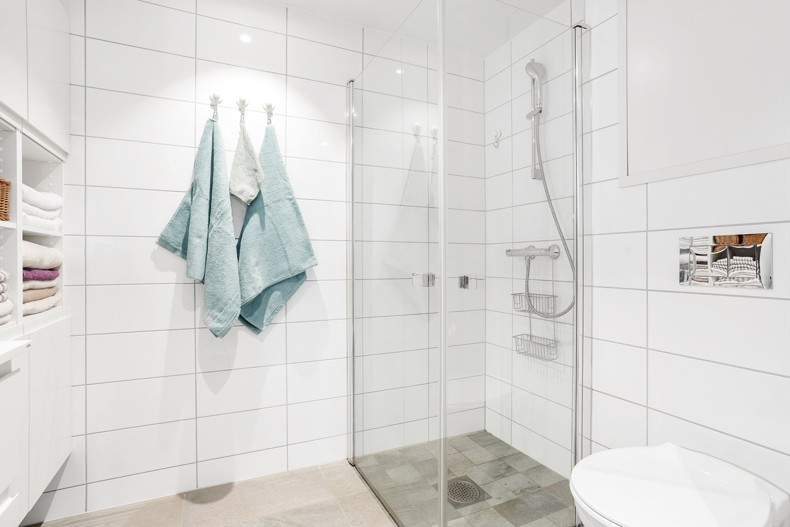 Videre har badet dusjhjørne med innfellbare dusjvegger og vegghengt toalett. Opplegg for vaskemaskin. Galleribilde