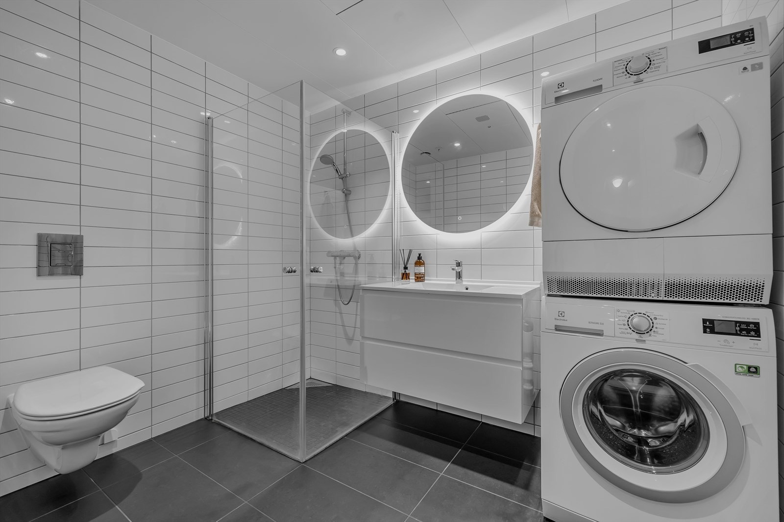 Badet er flislagt på gulv og vegger. Gulvvarme. Innslagbare dusjdører. Vegghengt WC. Galleribilde