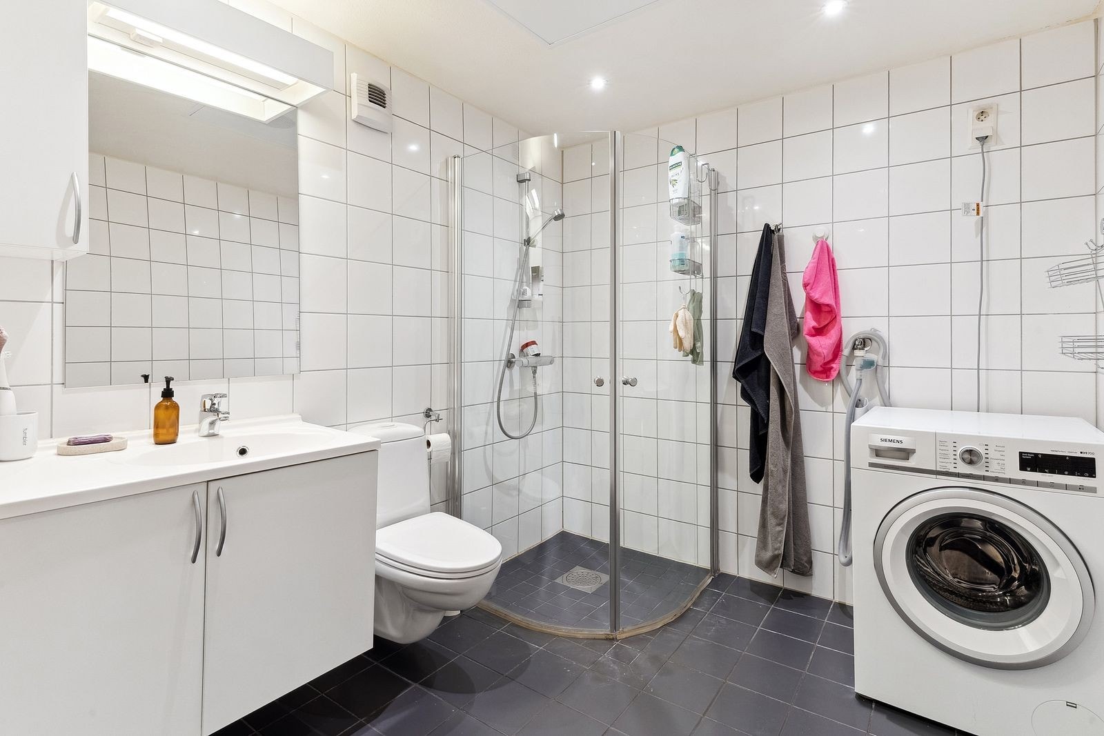 Lyst flislagt bad med vaskemaskin. Galleribilde
