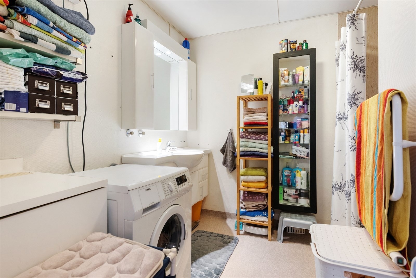 Badet er innredet med dusjvegger/hjørne, innredning med nedfelt servant og opplegg for vaskemaskin. Det er elektriske varmekabler i gulvet Galleribilde