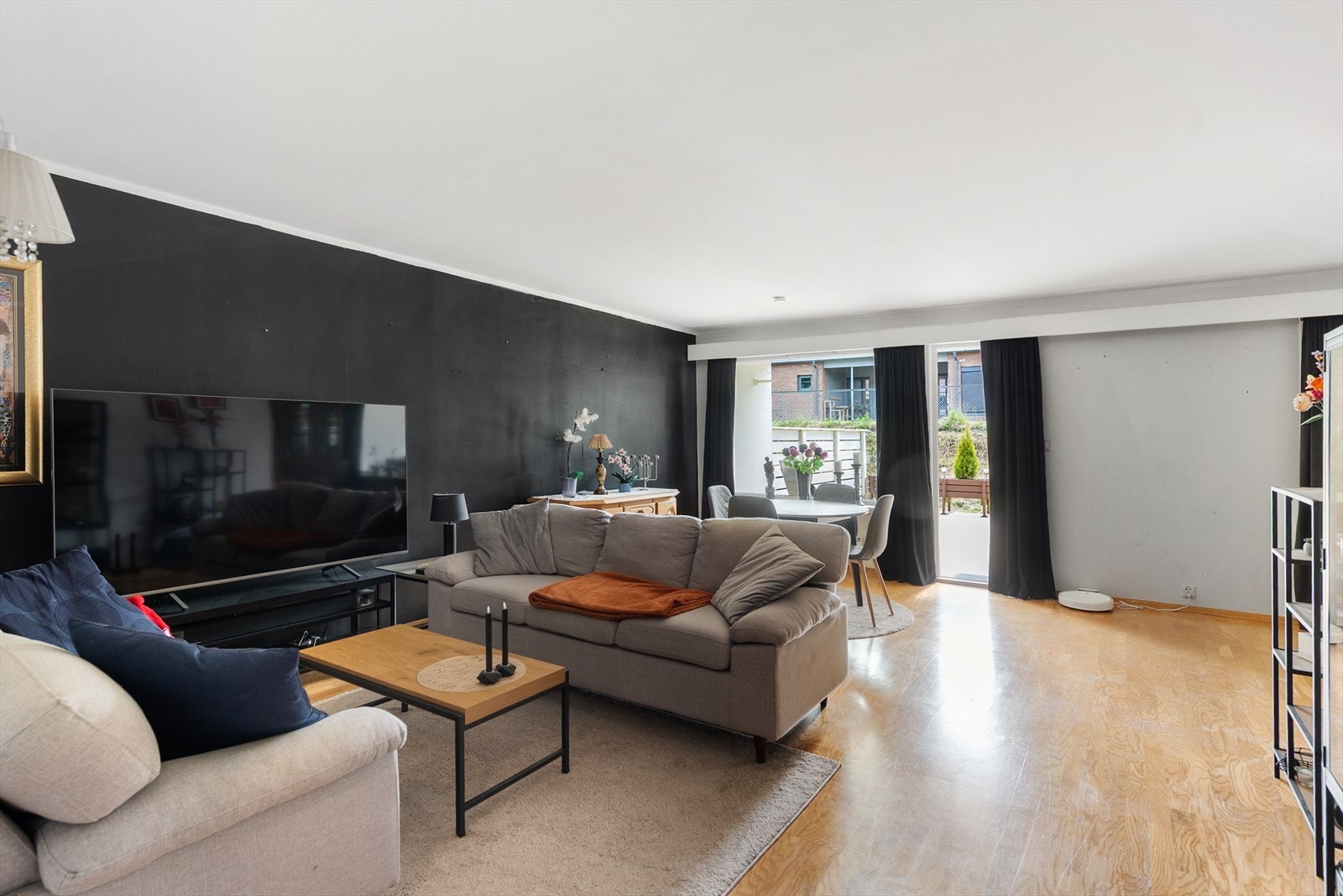Lys og romslig stue med plass til sofa, spisebord og diverse møblement Galleribilde