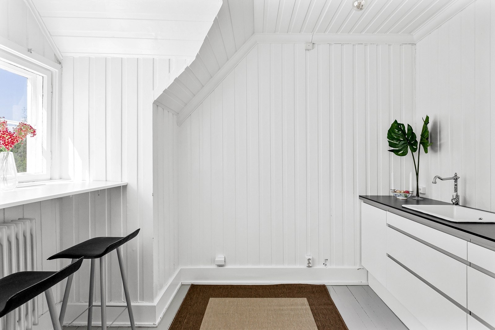 Kjøkkeninnredning med vask og bord med barstoler. Galleribilde