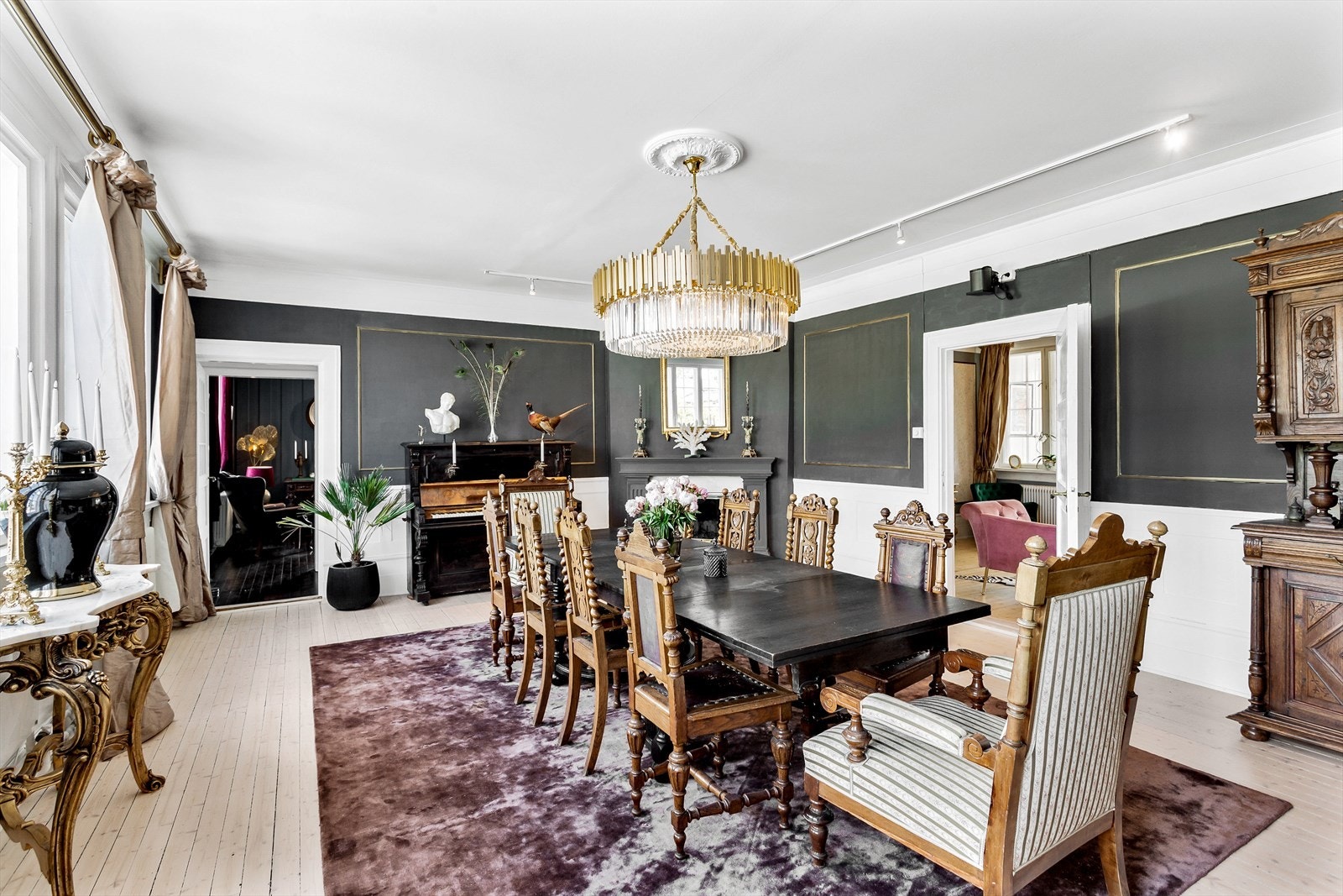 Spisestuen har peis og flotte detaljer på veggene. En nydelig lysekrone troner midt i rommet! Galleribilde