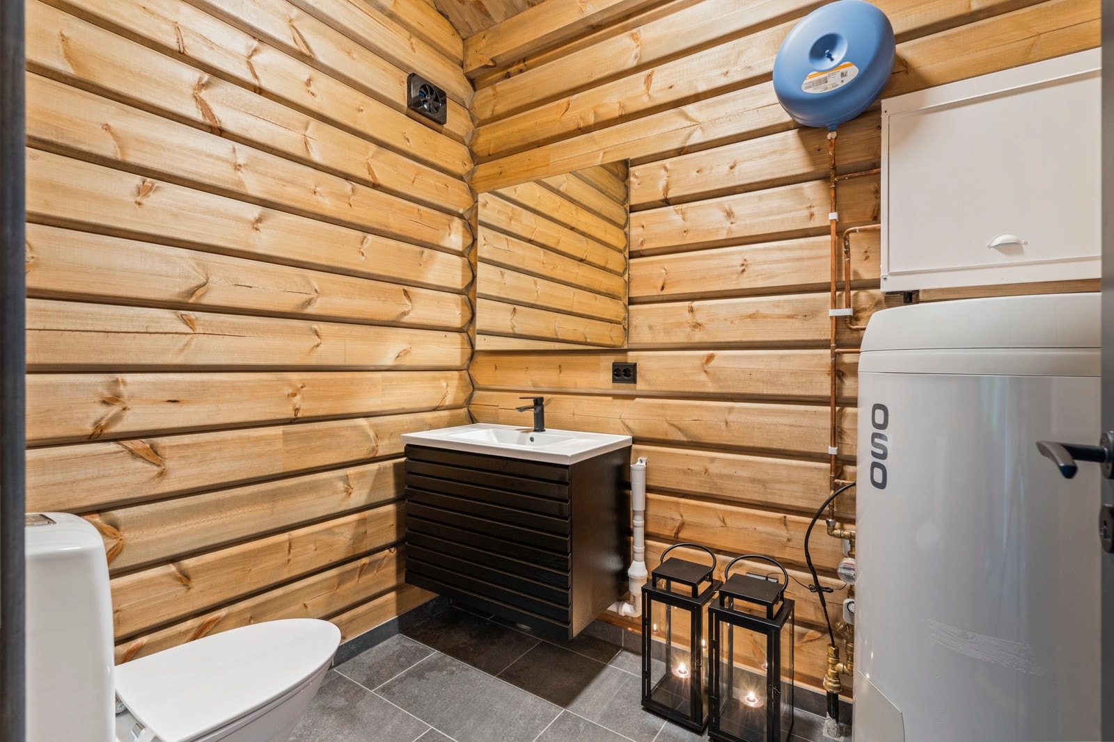 Rommet har innredning med benk m/vask og speil, wc og opplegg for vaskemaskin. Galleribilde