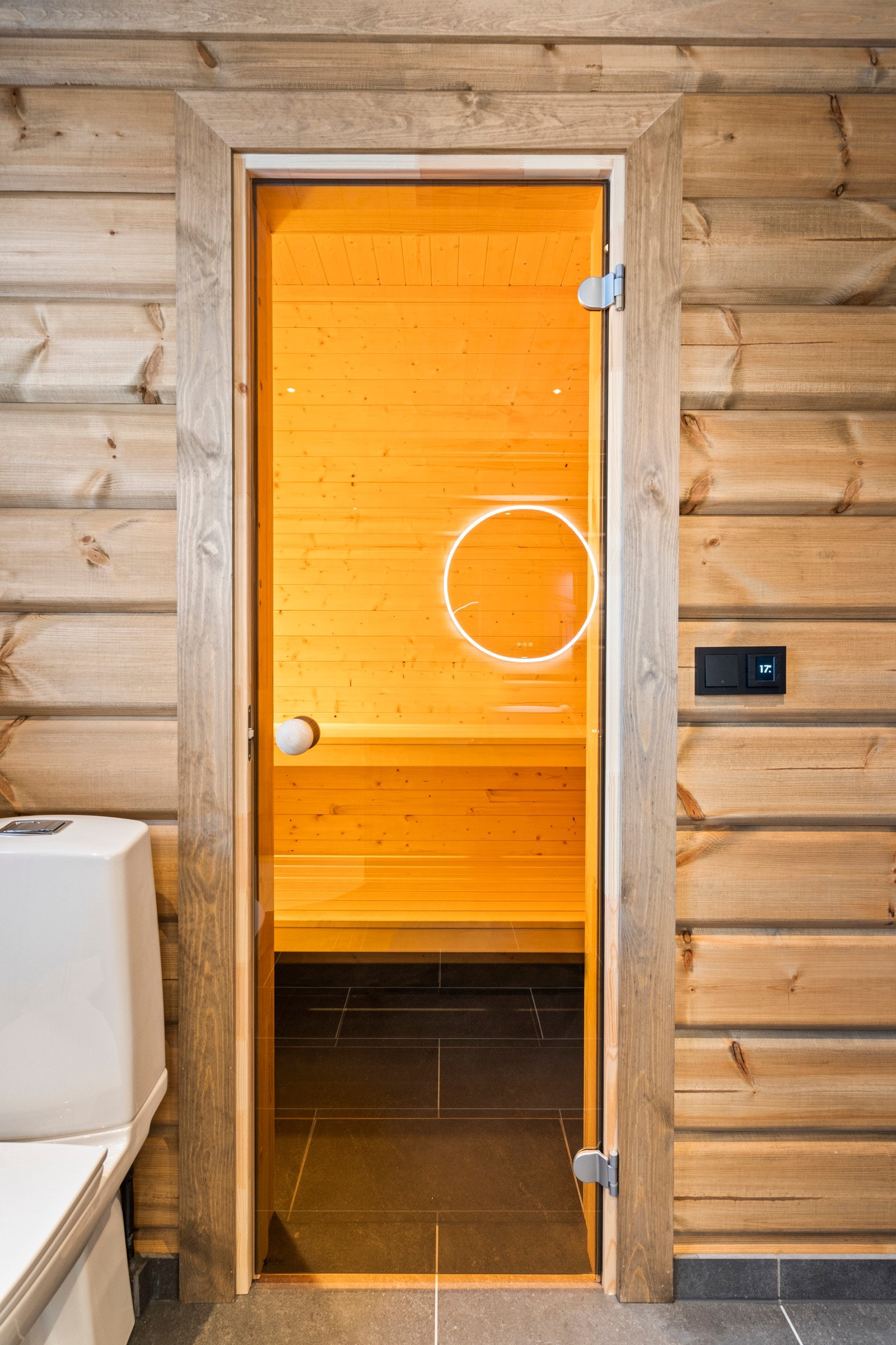 Badstu har dør av herdet glass, gulv med flis, vegger og tak i granpanel. Benker i osp. Elektrisk badstuovn. Galleribilde