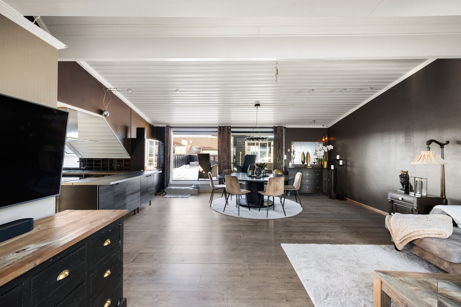 En stor og åpen gulvflate gjør stuen enkel å møblere. Sitteplass er det også langs kjøkkenets smarte barløsning. Galleribilde