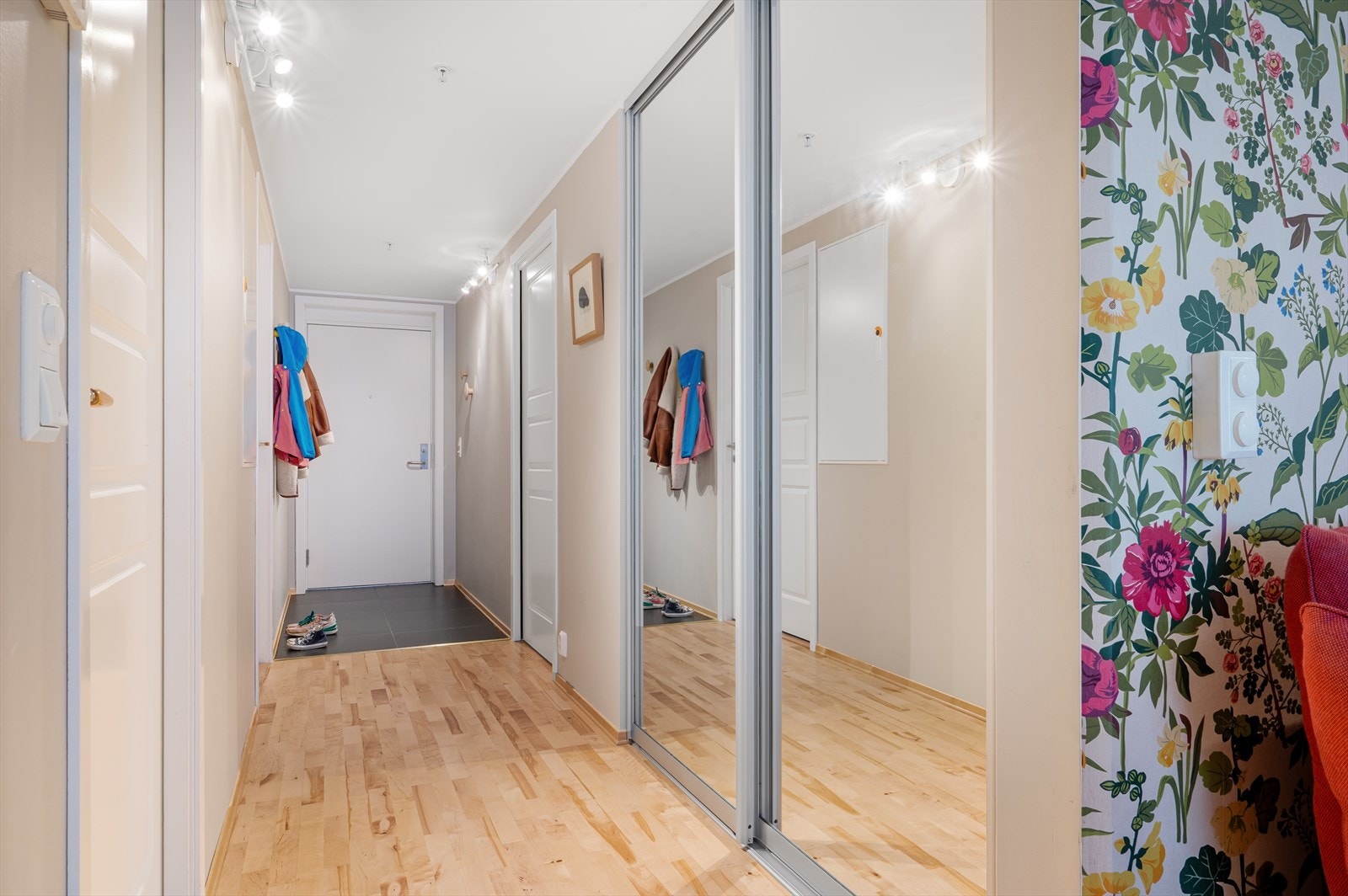 Innbydende entré innredet med et romslig gulv til tak garderobeskap med speil - perfekt for oppbevaring av yttertøy. Galleribilde