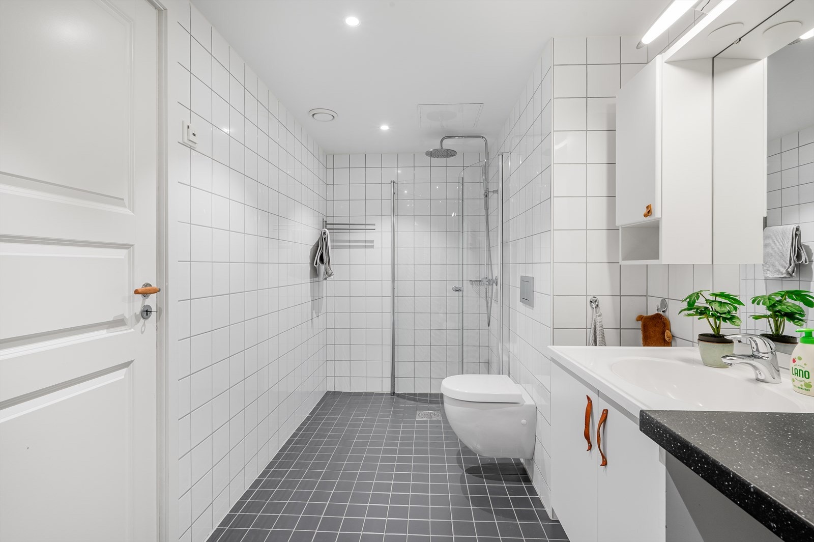 Sanitærutstyr på badet er dusjhjørne m/glassdører, vegghengt toalett, laminert benkeplate, opplegg for vaskemaskin og servant med innredning/speil/belysning. Galleribilde