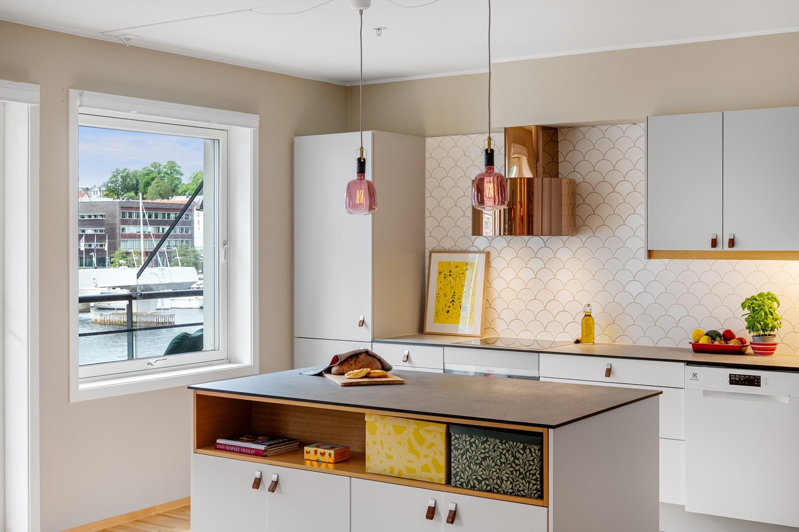 Det er fliselagt mellom benkeplate og overskap. Galleribilde