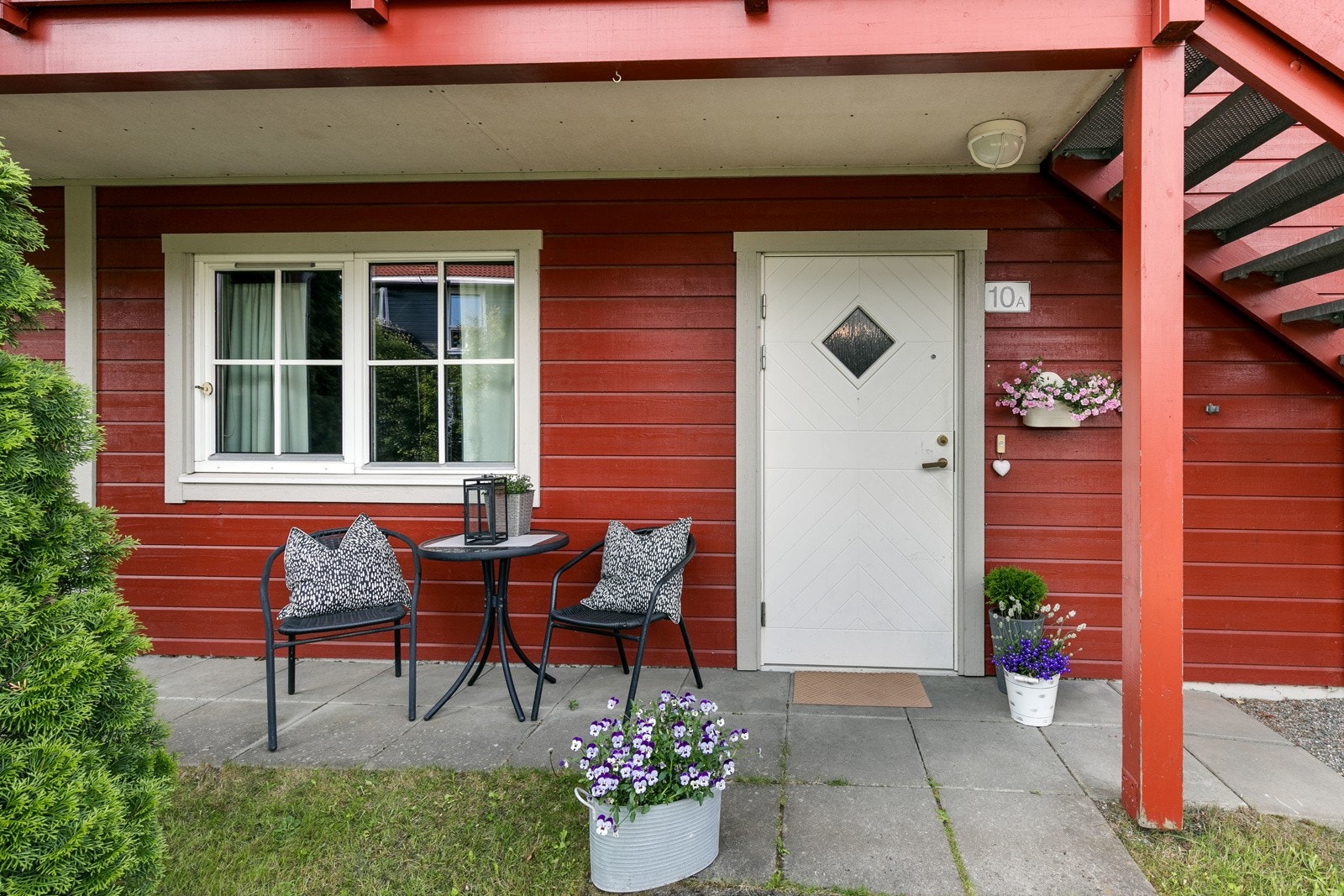 Ved boligens inngangsparti er det en anlagt en koselig hellelagt uteplass med plass til 2 stoler og lite bord. Galleribilde