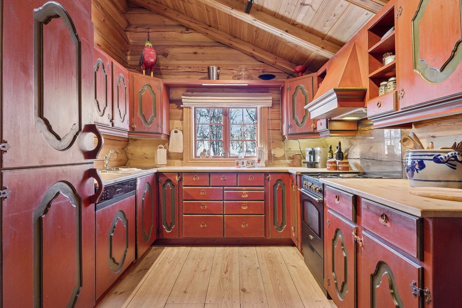 Kjøkkenet har plassbygget innredning fra Norske Bygdemøbler med profilerte dør- og skuffronter. Benkeplate er av typen heltre. Komfyr med gass og kokeplate, oppvaskmaskin og kjøl/frys samt alt en måtte trenge av skap-, skuff og benkeplass. Galleribilde