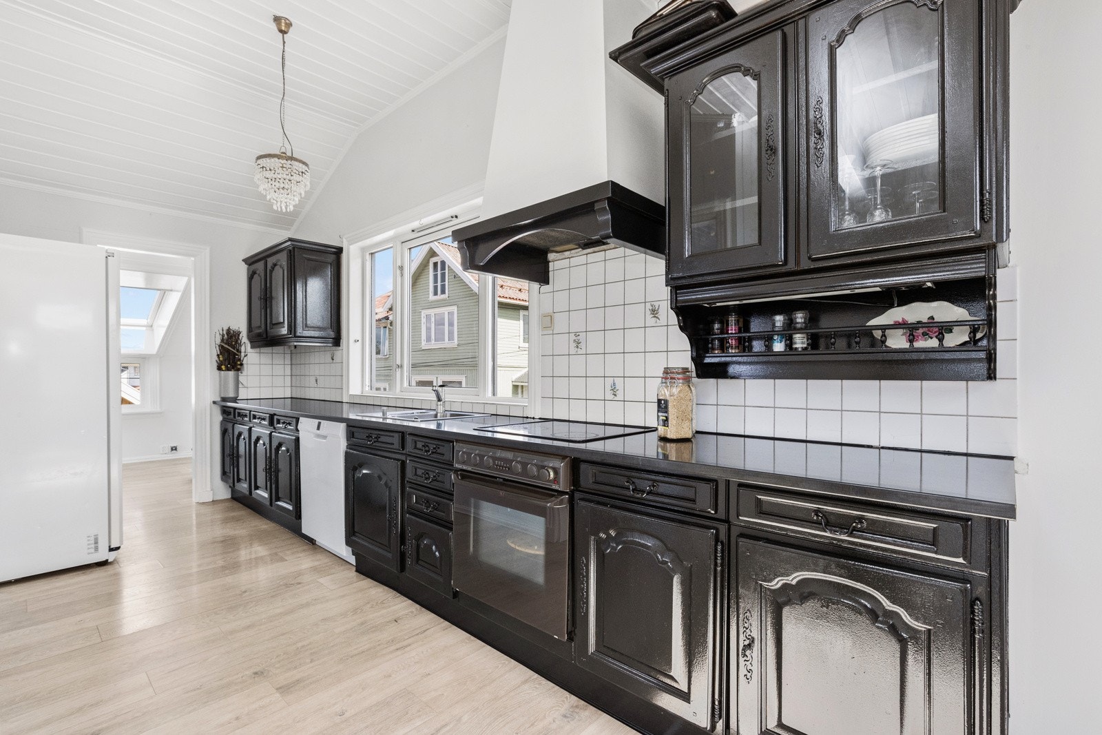 Sosial, åpen kjøkkenløsning mot stuen. Innredning moden for utskiftning. Galleribilde