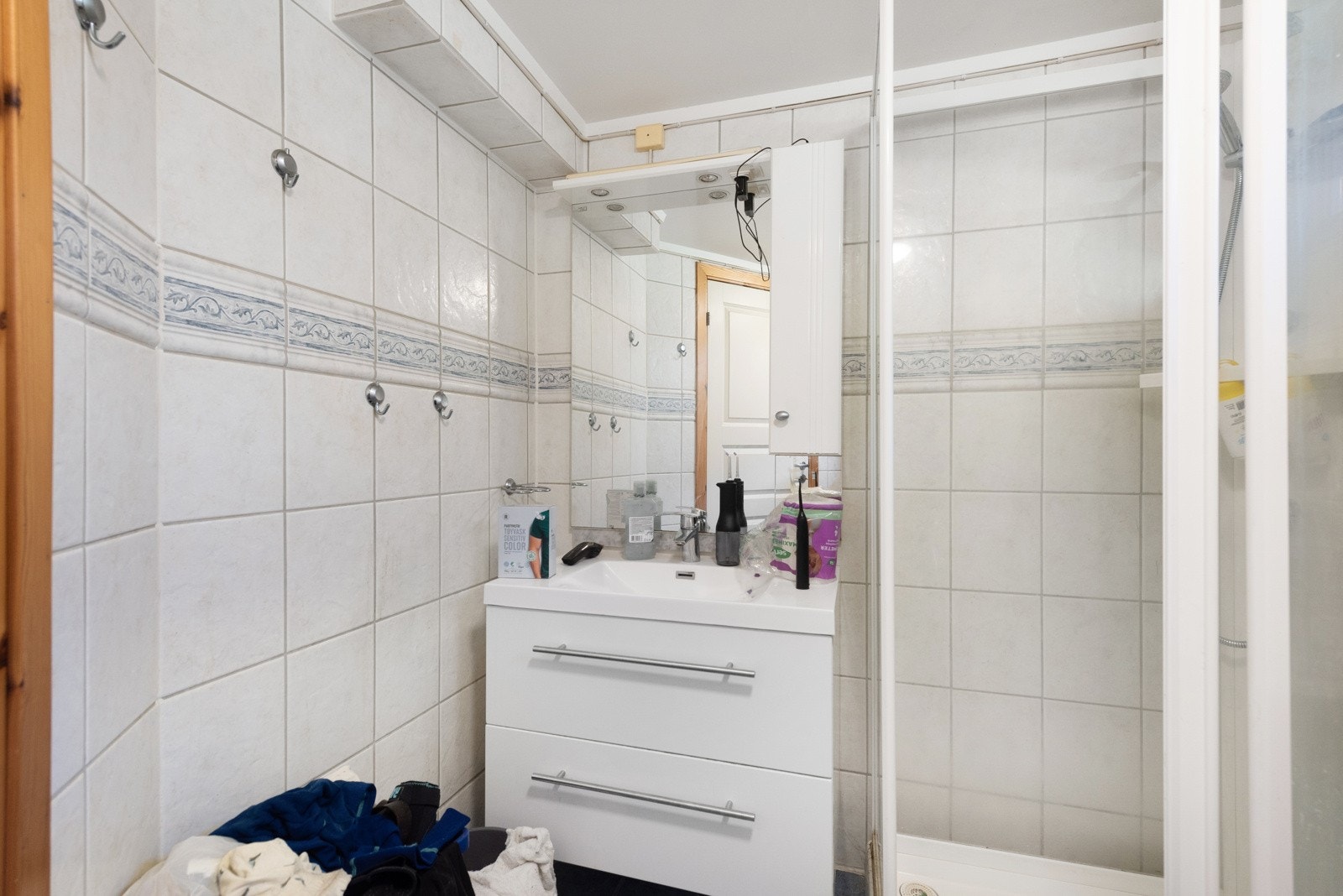 Rommet er innredet med dusjkabinett, servant i innredning med skuffer, toalett og opplegg til vaskemaskin Galleribilde